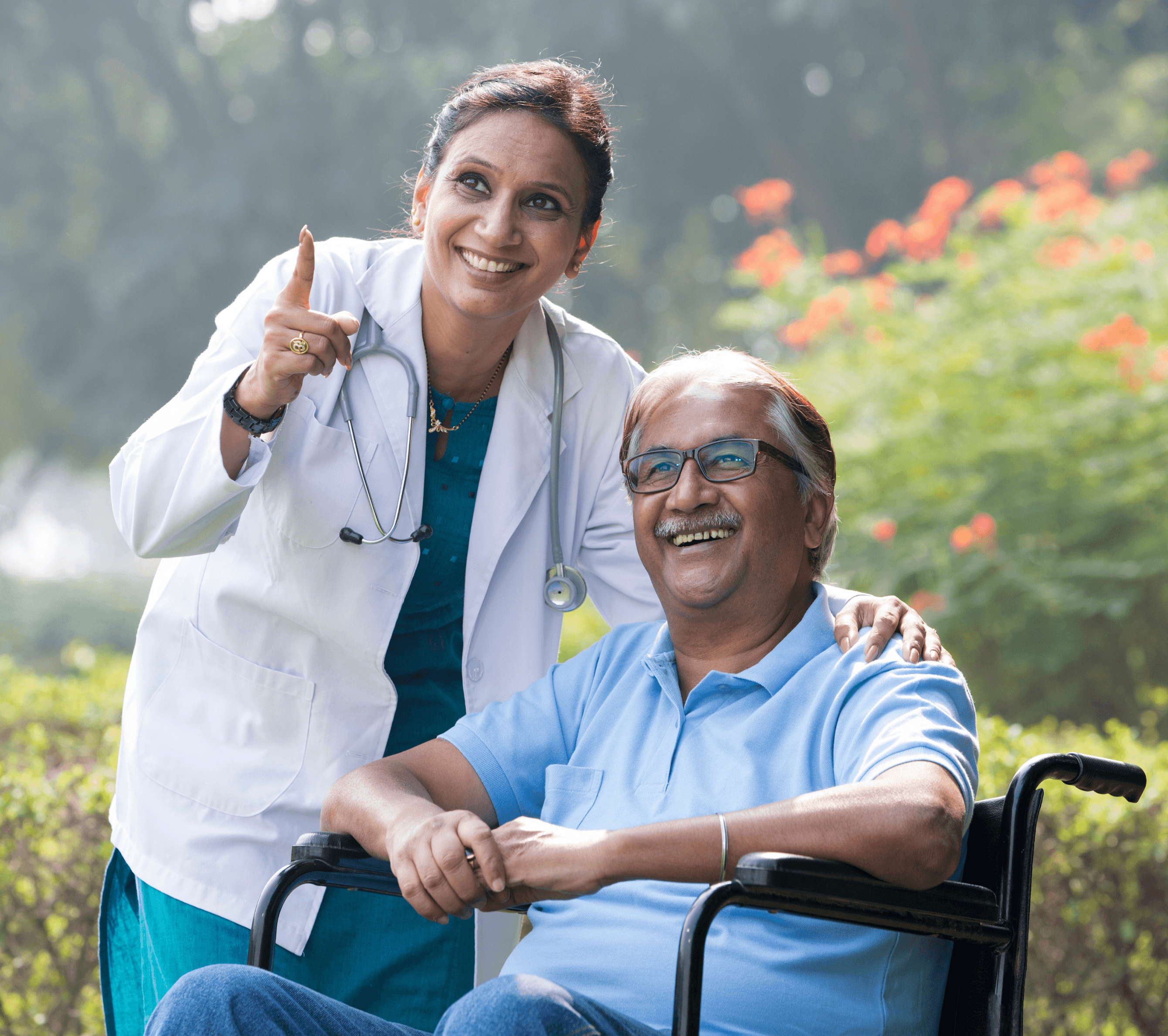 Smiling doctor with elderly patient in wheelchair outdoors, representing compassionate care at Sibia Medical Centre