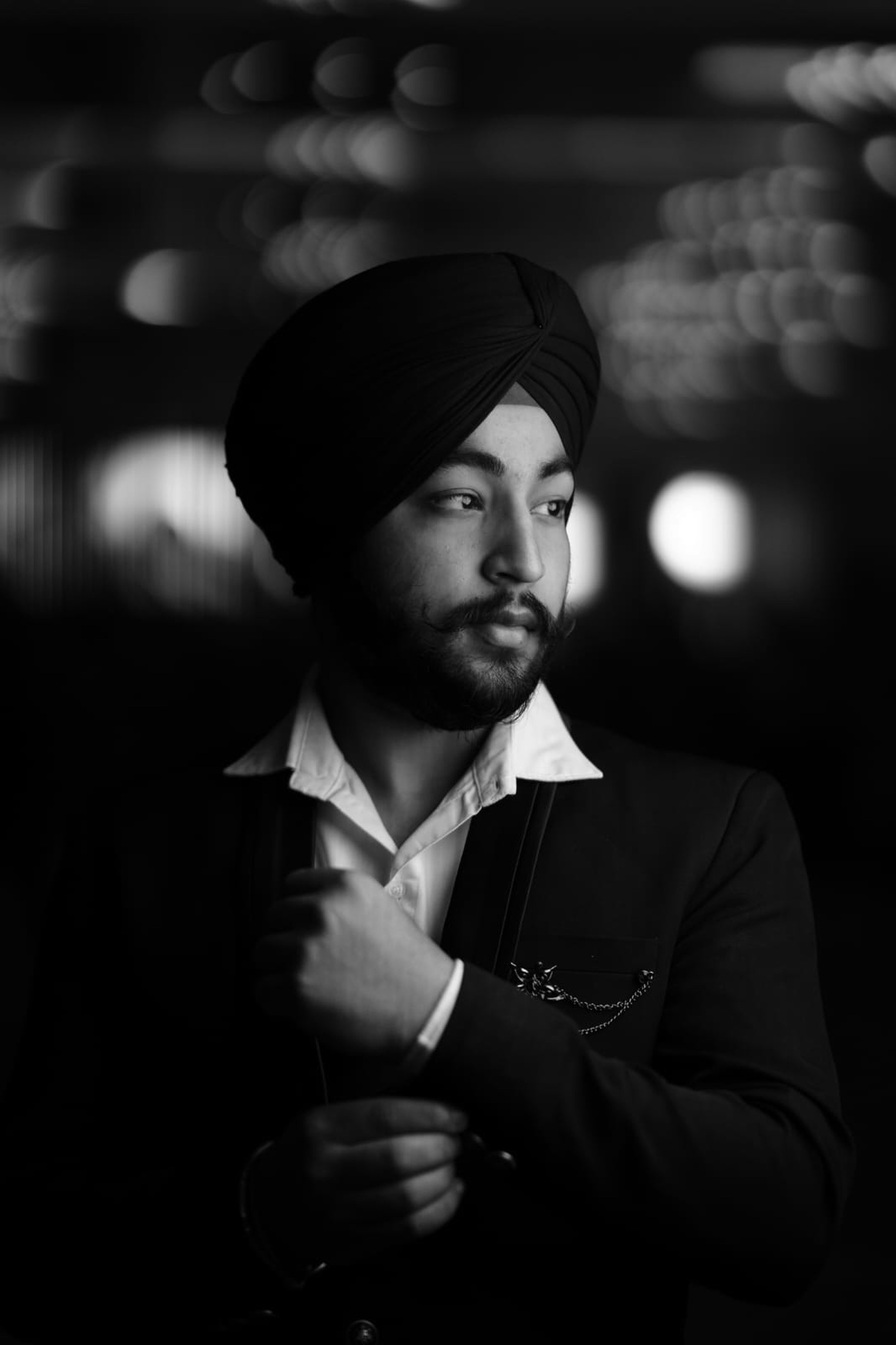 A man in a turban standing in a dark room