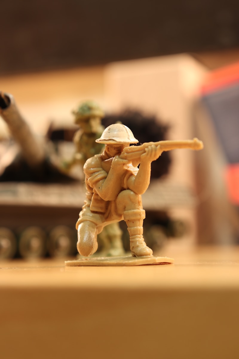 Man in coat holding rifle figurine