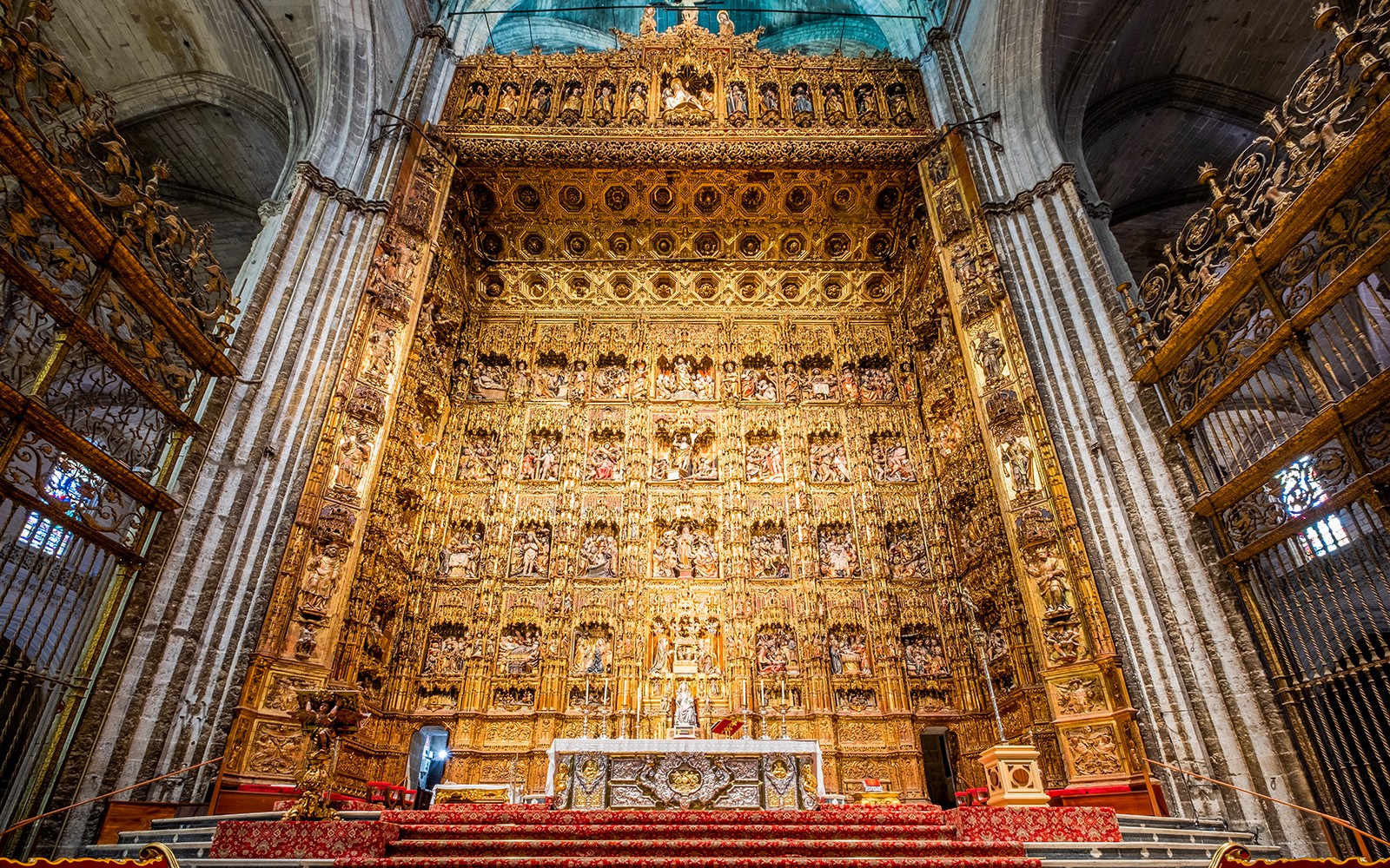 Altar of Seville Cathedral with intricate gold detailing on a guided tour.