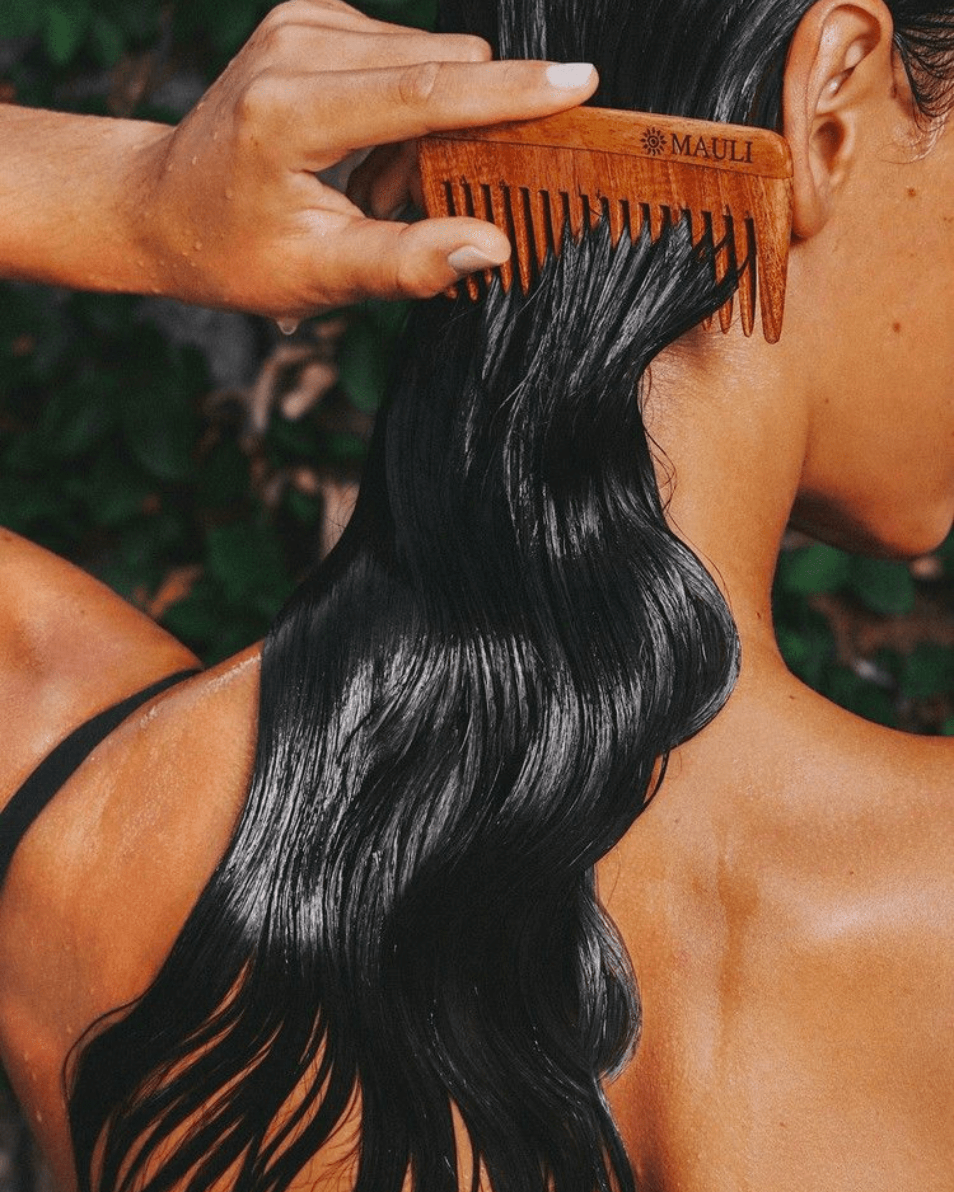 View of the French countryside through a stone villa’s open living room, with sofas and trees framing the scene