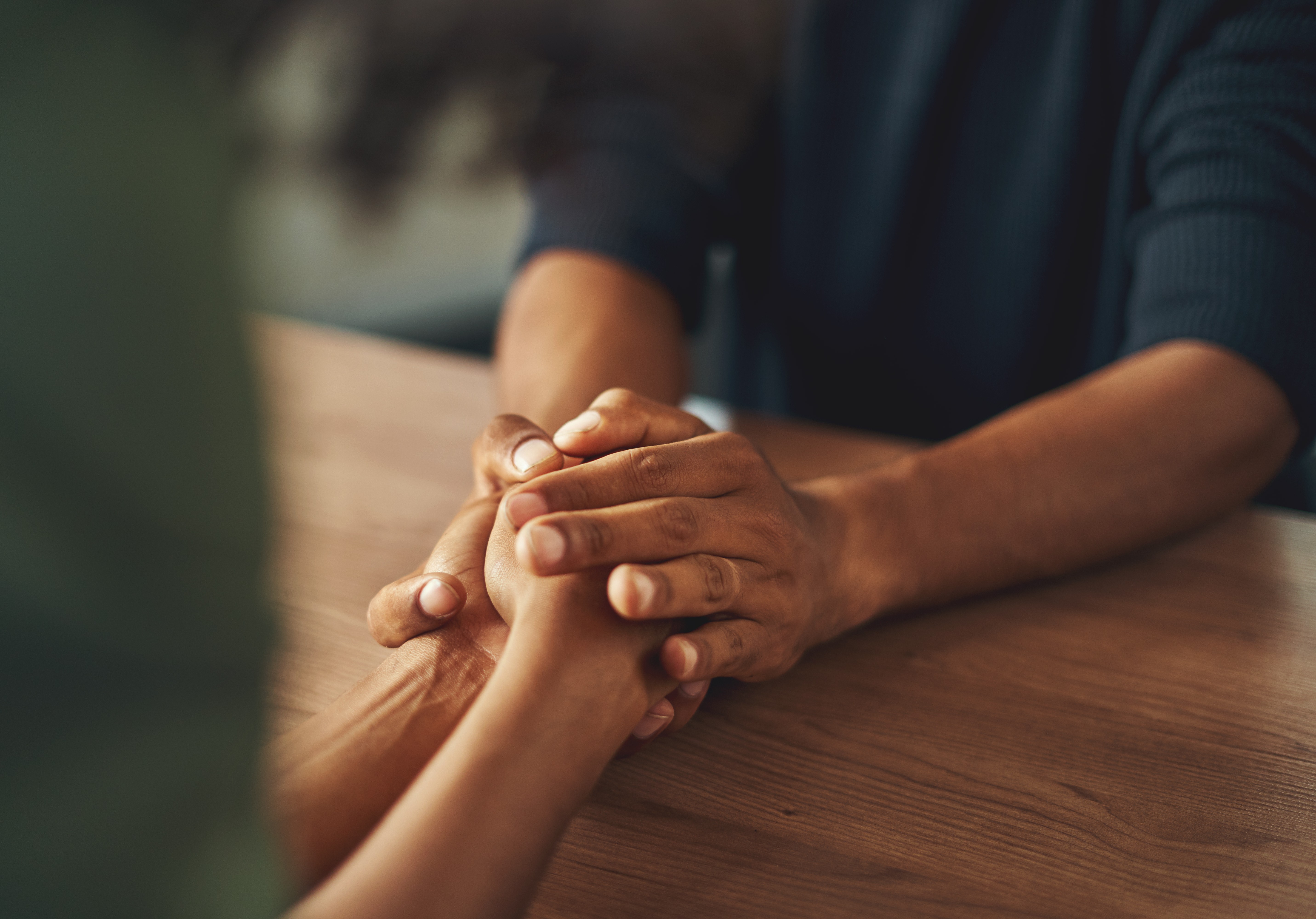 Two people holdong hands at a table