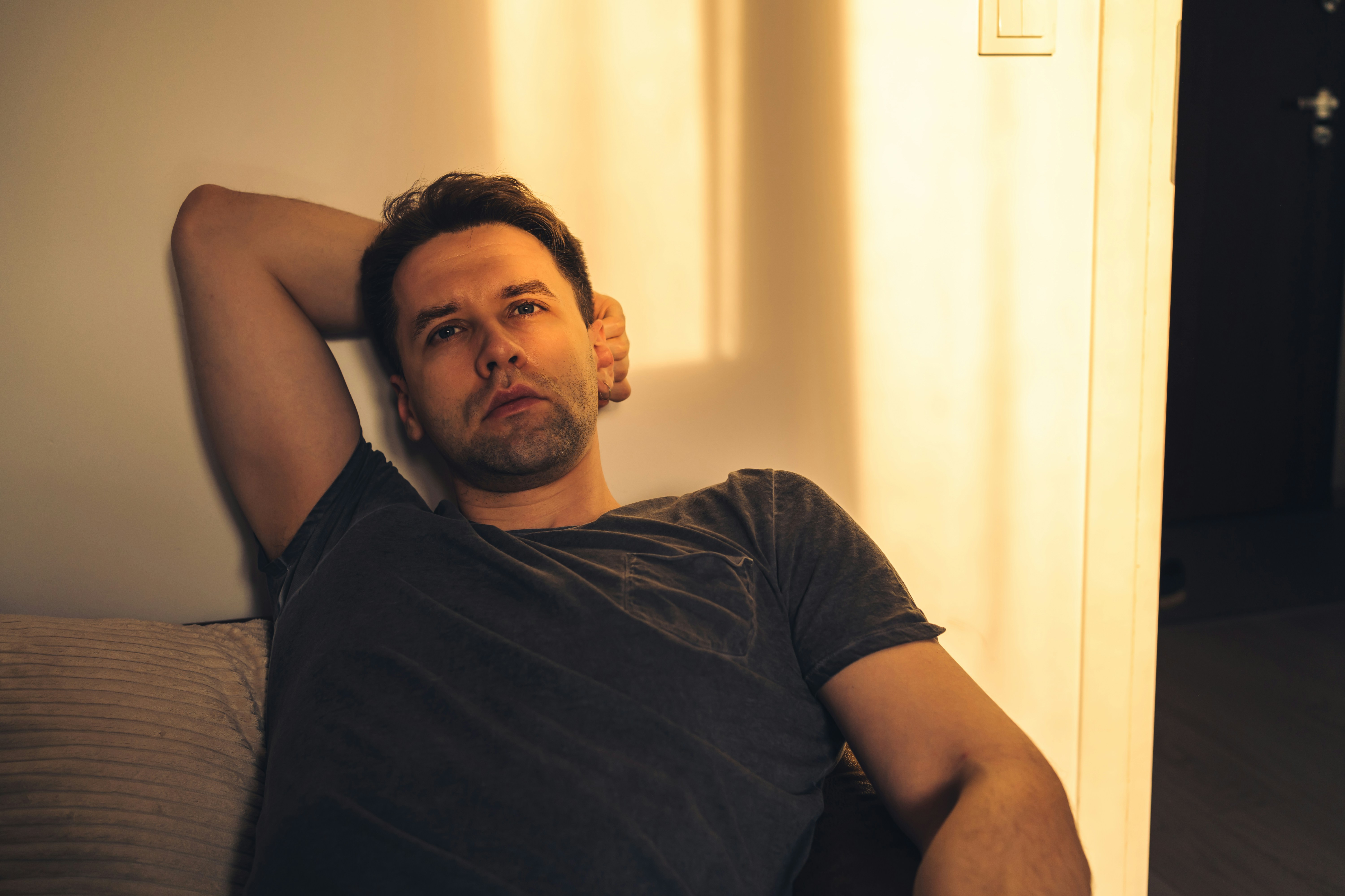 a man laying on top of a couch next to a wall