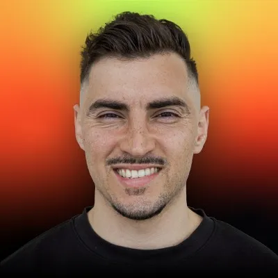 Man with mustache smiles, orange and yellow background.
