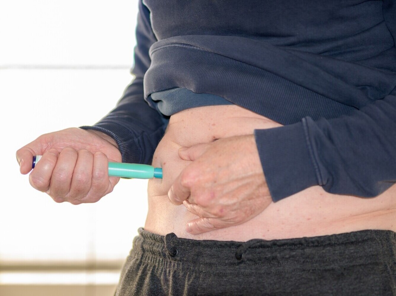 man injecting a prescription weight loss med into his stomach