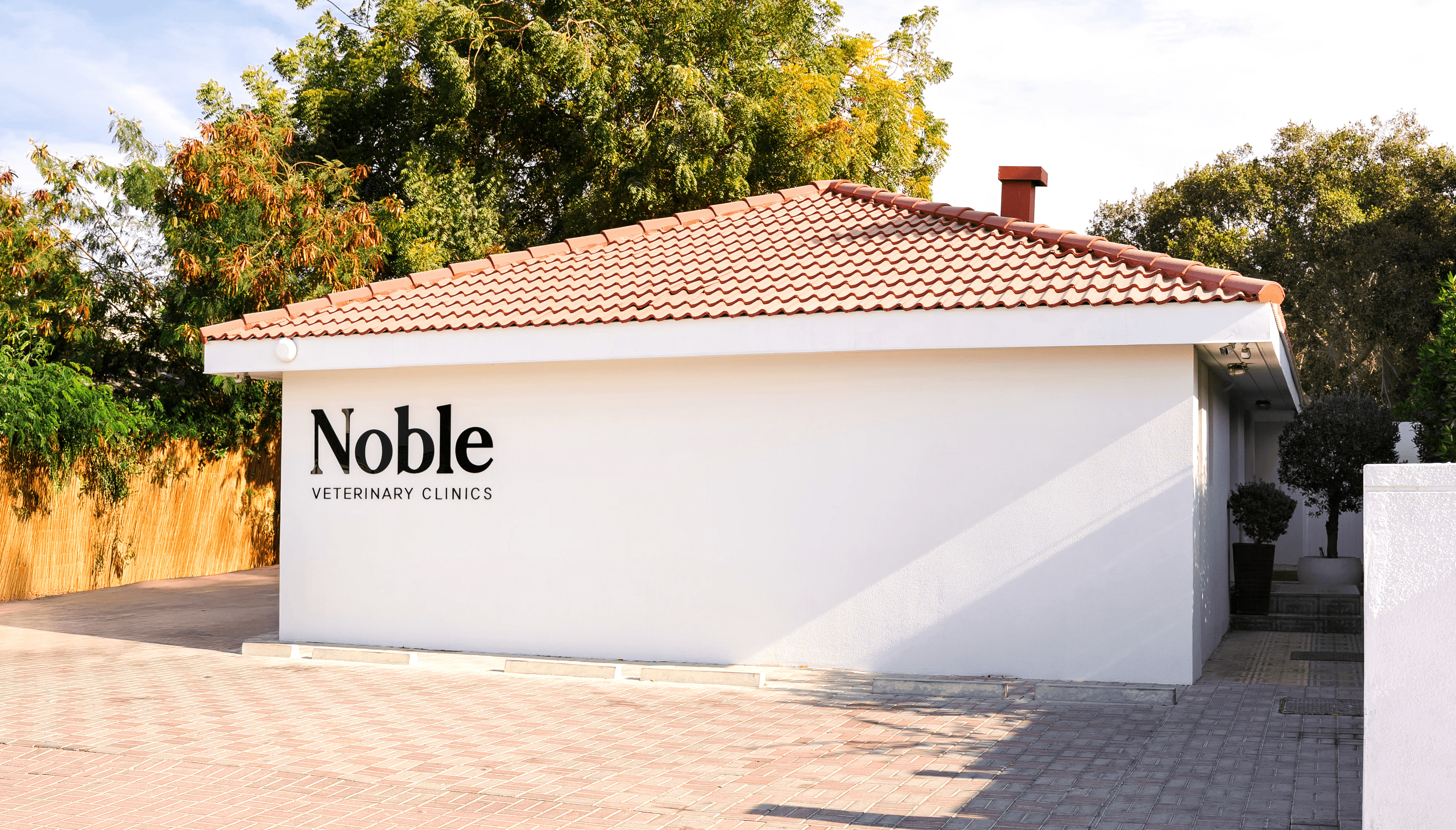 The front of Noble Veterinary Clinic in DIP, Dubai. Our vet clinic features glass doors and windows with reverse silhouettes of pets on the windows surrounding the doors.
