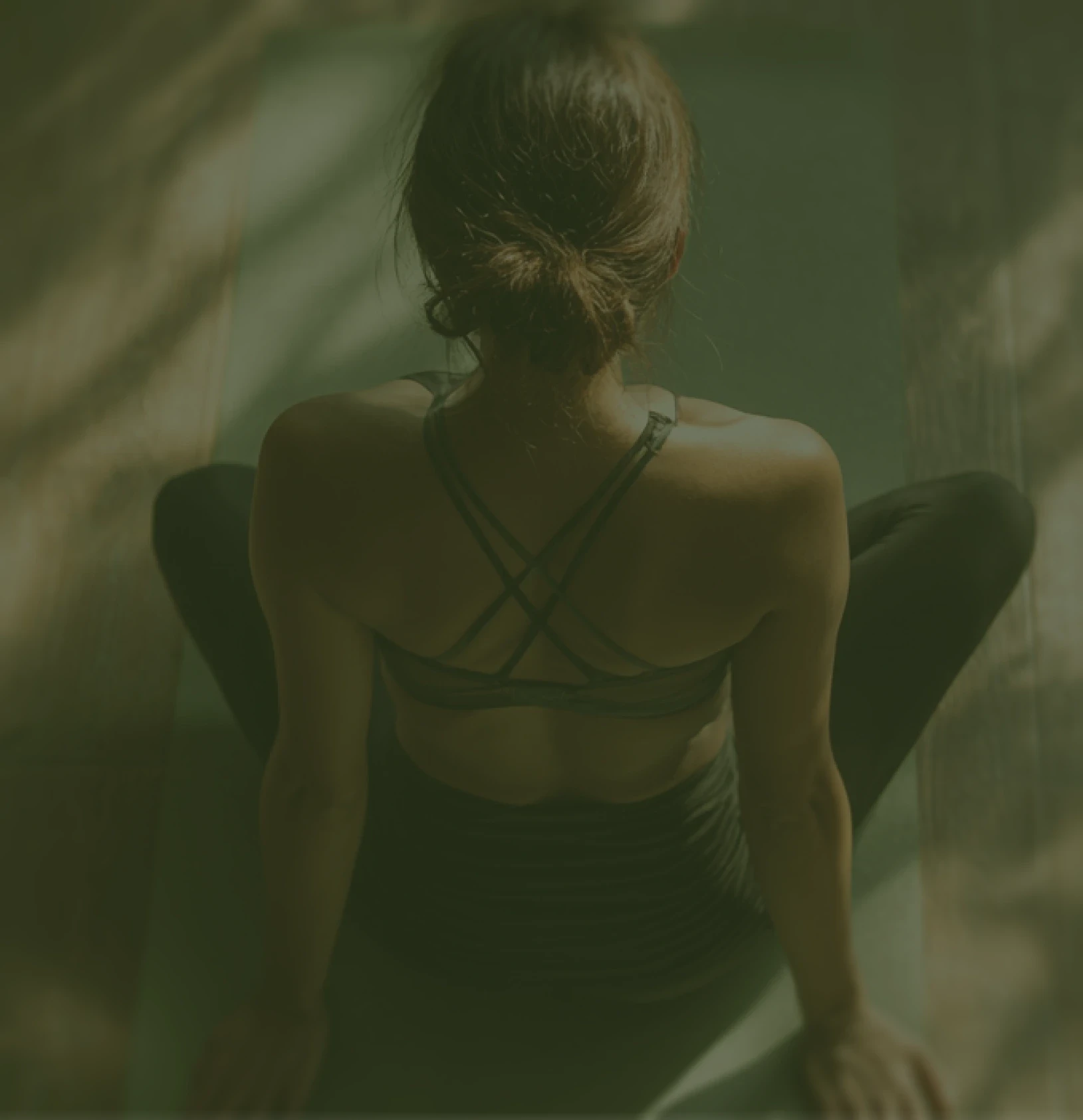Woman sitting in a yoga pose from behind