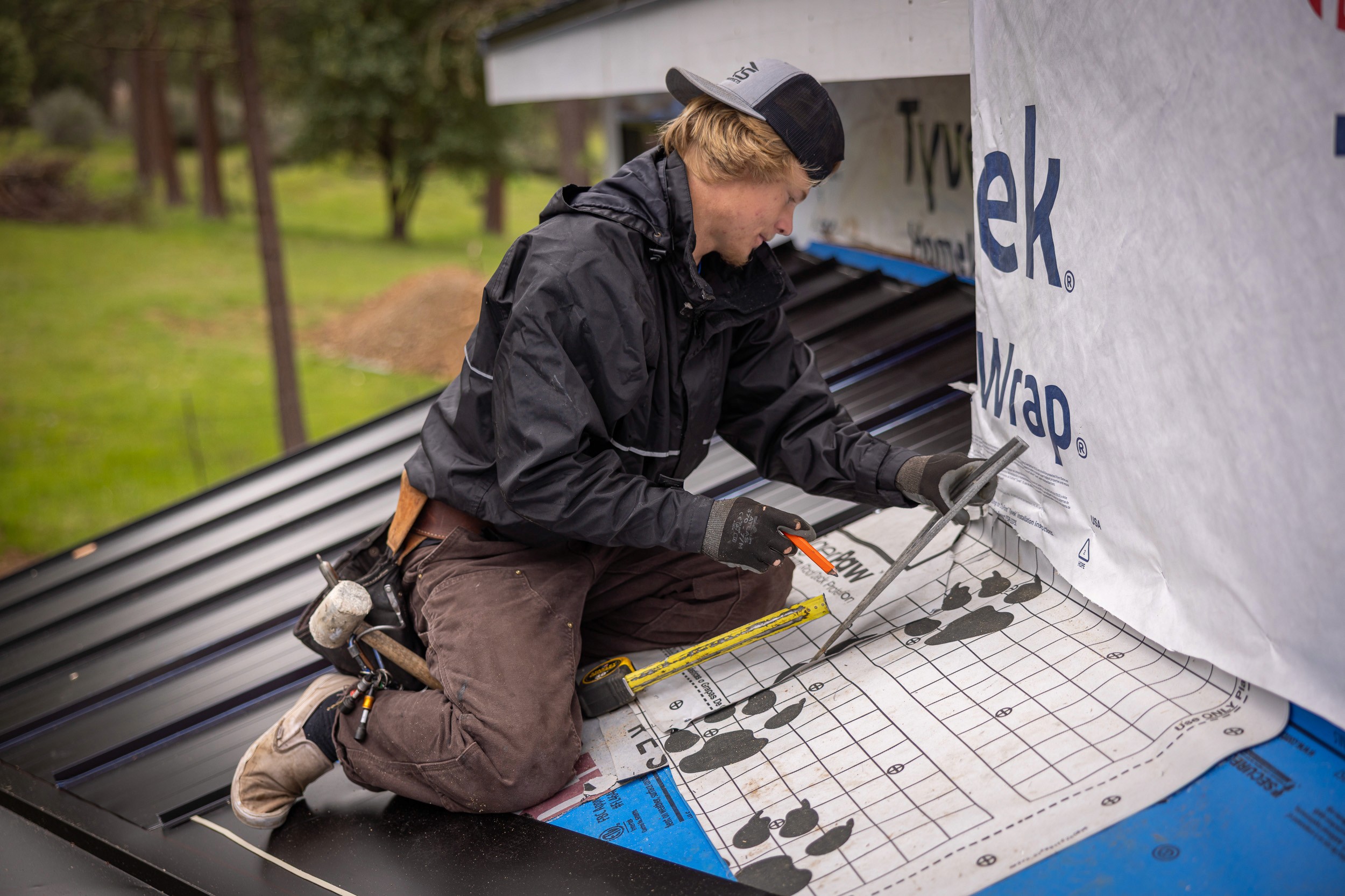 Roofer repairing metal roof on a residential home in Medford, Oregon