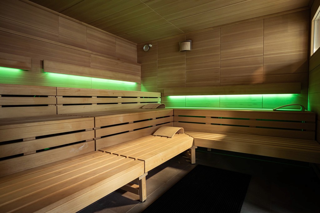 Sauna im XTRAFIT Fitnessstudio in Köln-Marsdorf mit Holzinterieur und grüner Beleuchtung.