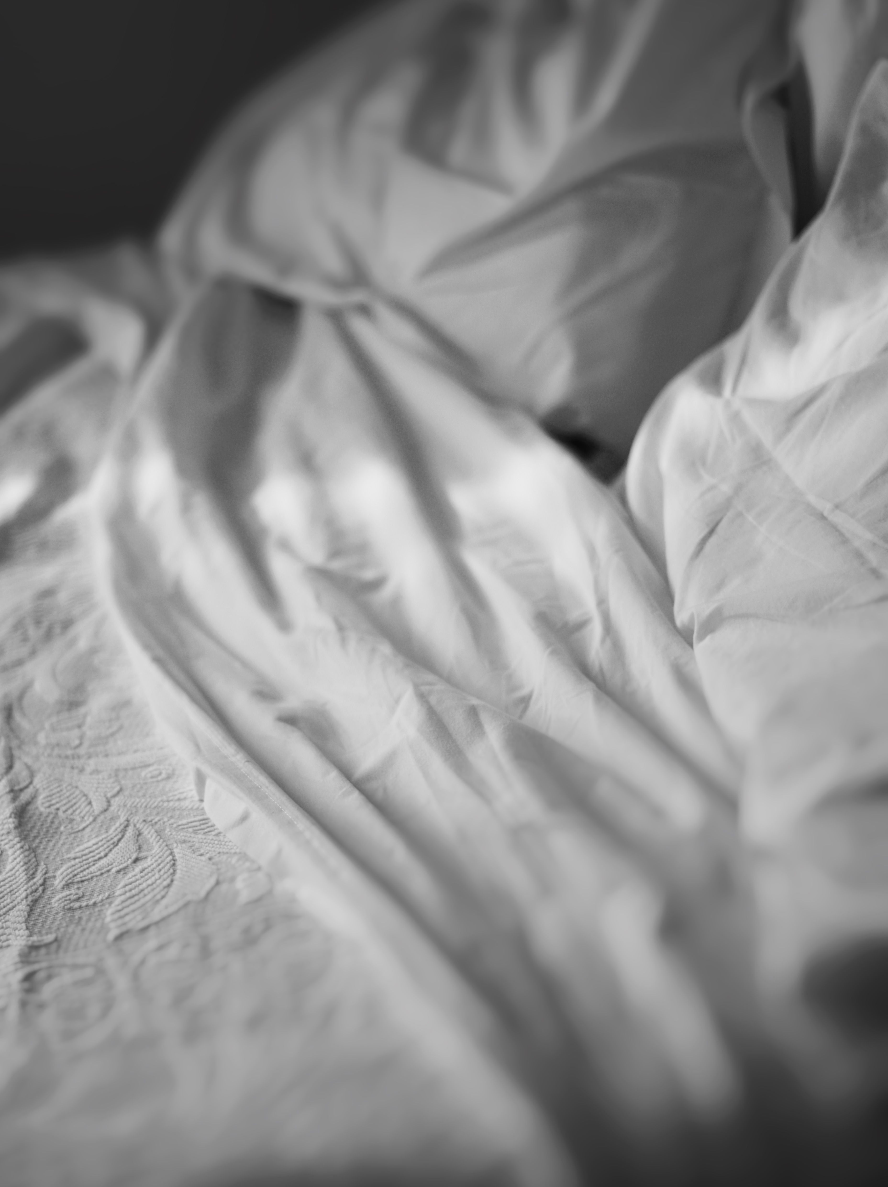 close-up-of-crumpled-white-bedding-with-intricate-textures-in-black-and-white. - quiet-shades-of-brown (pexels)
