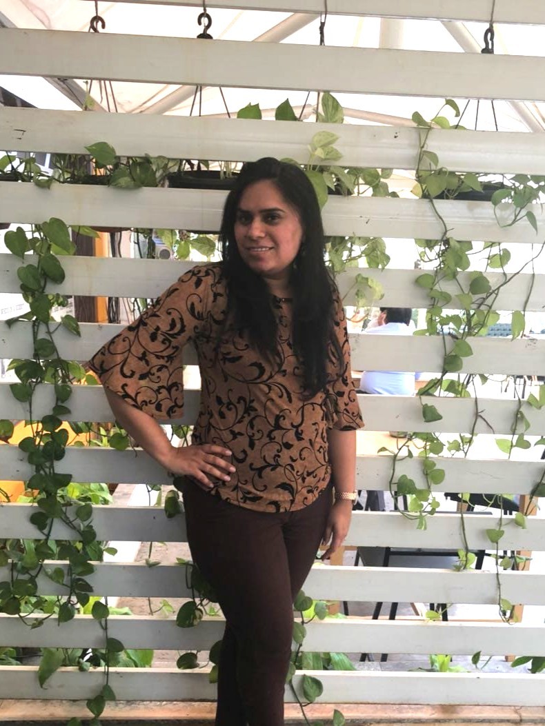 A businesswoman sitting at her desk, smiling and looking at the camera.