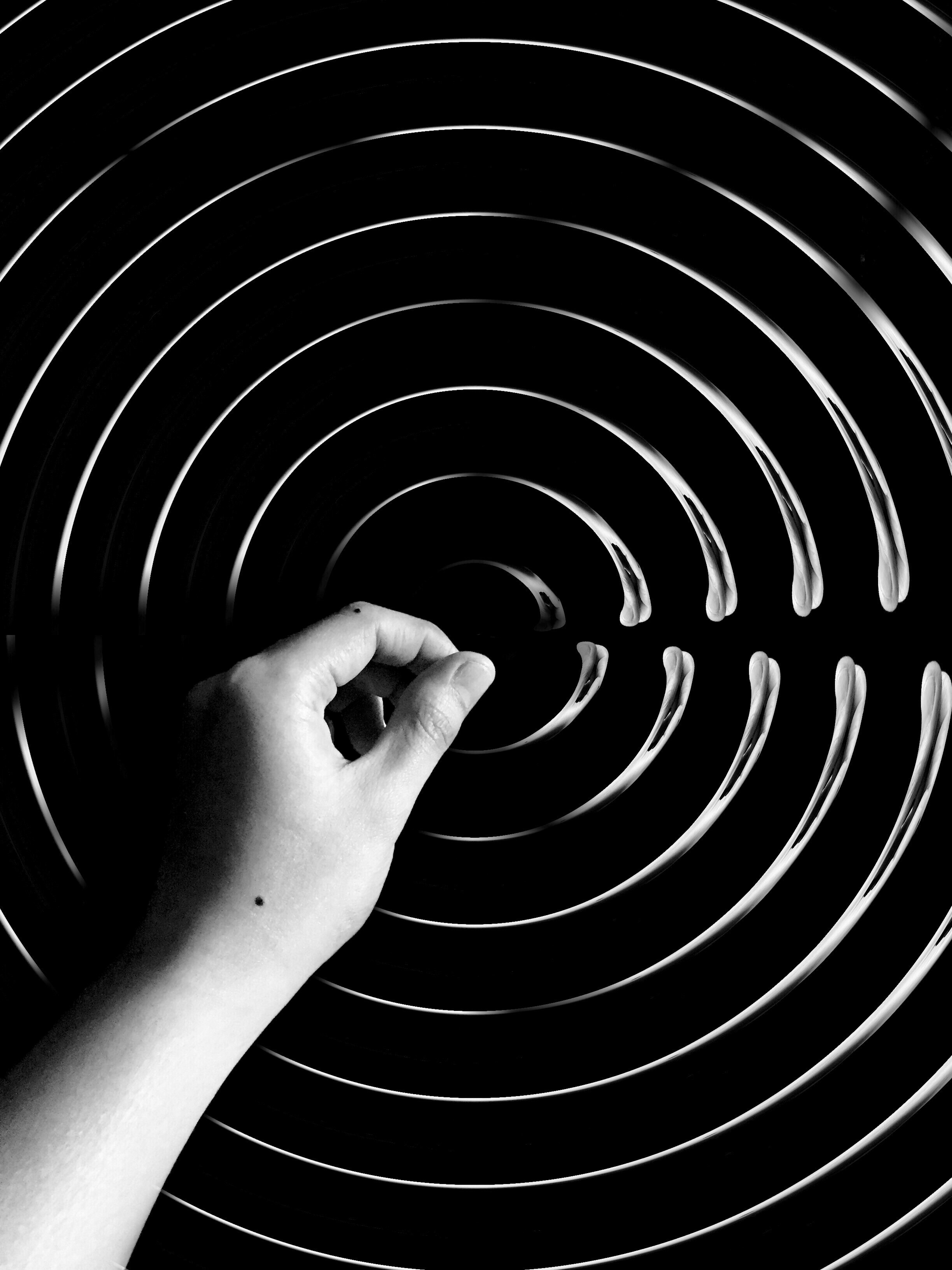 Abstract close-up of a finger creating ripples or sound waves.