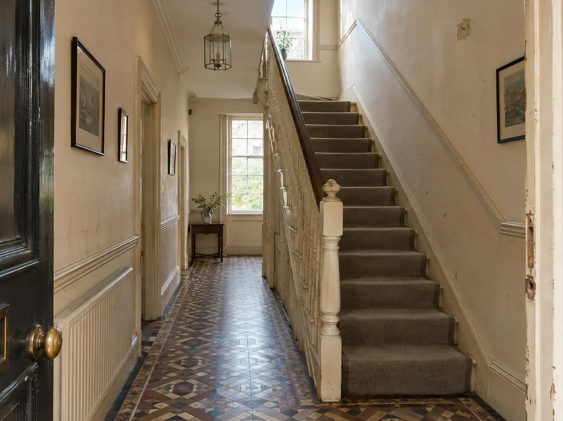 A Victorian hallway before decorating: tired cream walls with chipped paint, a worn door frame and the original tiled floor