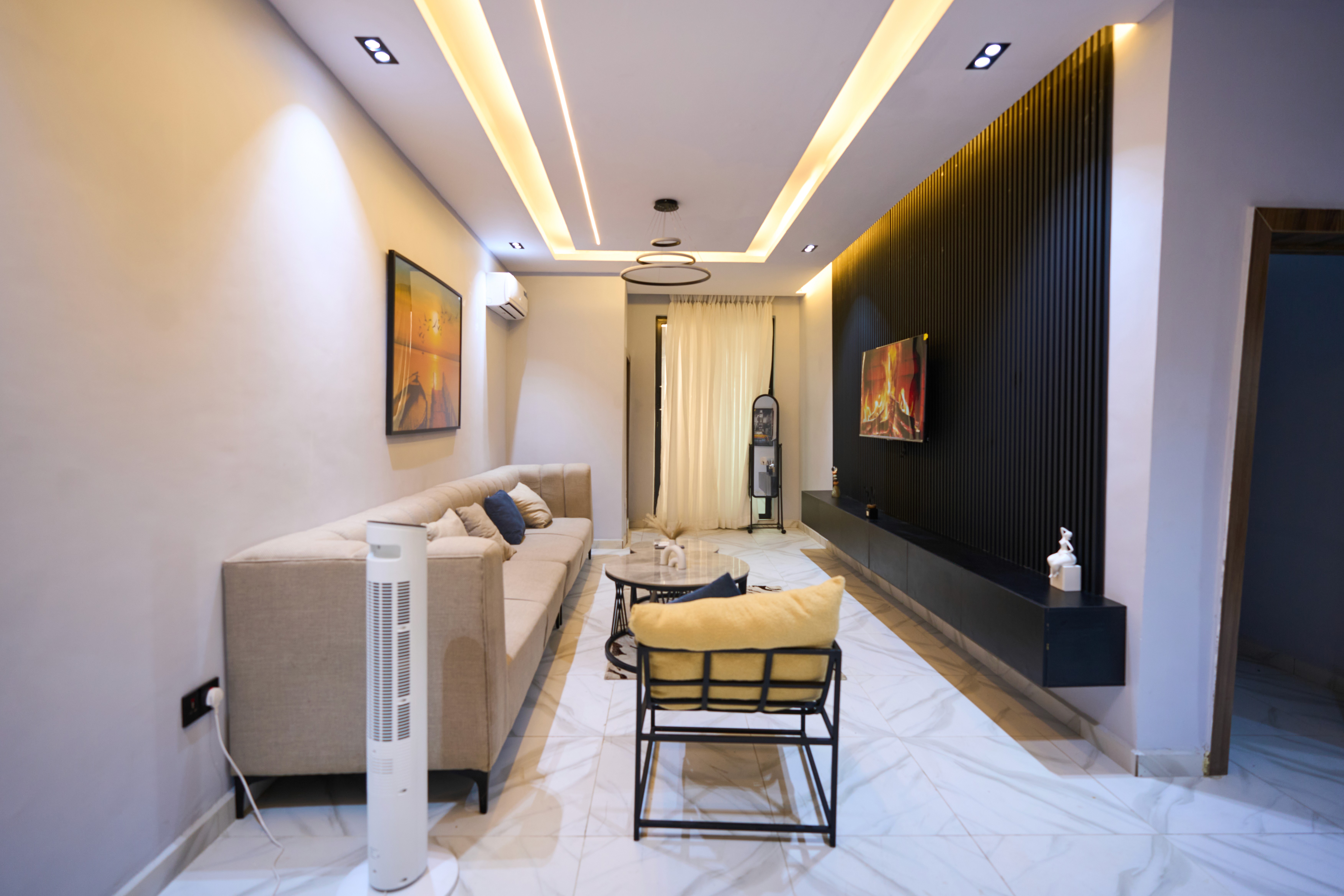 Modern luxury house on a hillside surrounded by trees, featuring large glass windows, a terrace, and a small pool at sunset.