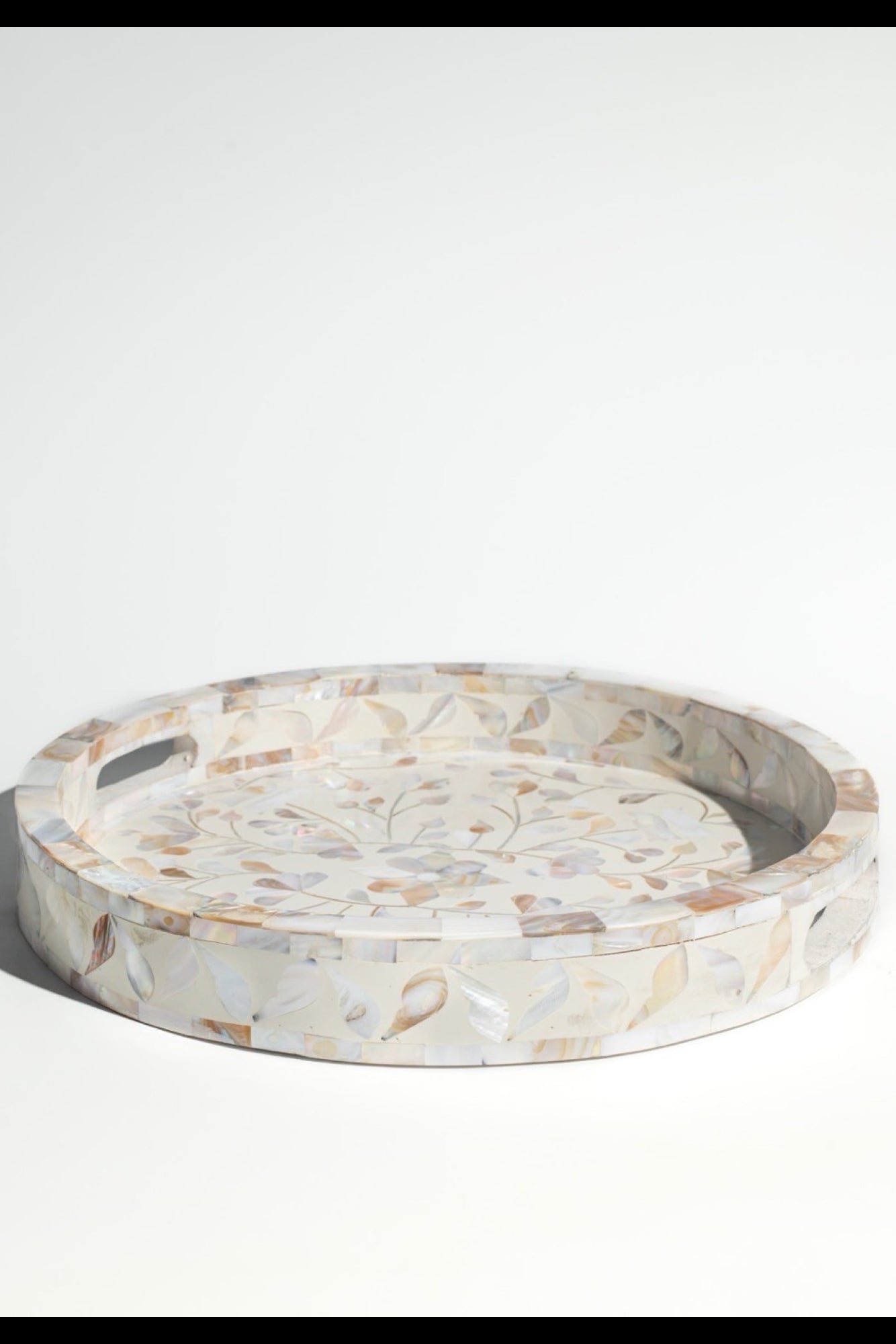 Round marble tray with floral patterns on a white background