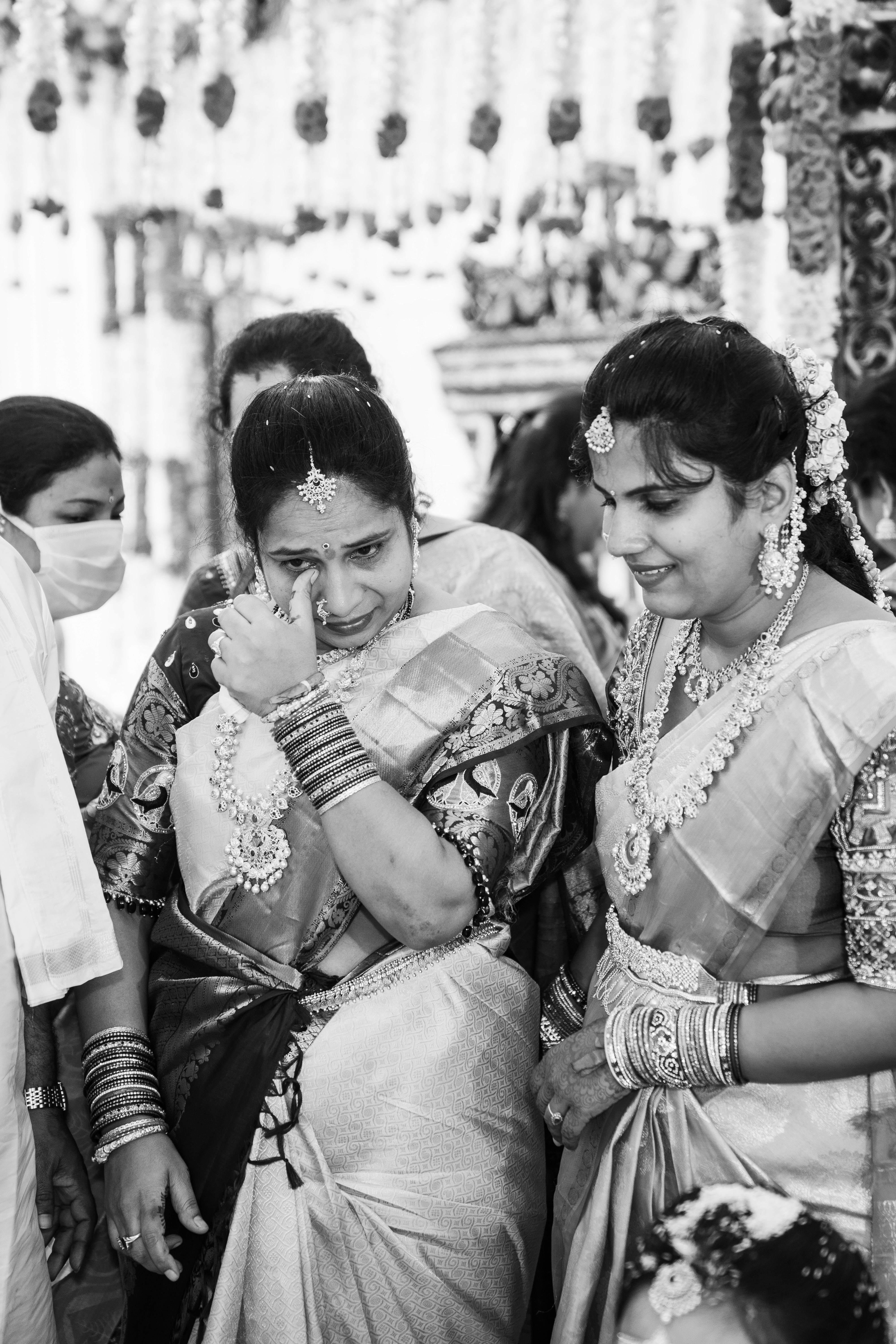 A couple stands outdoors at sunset.