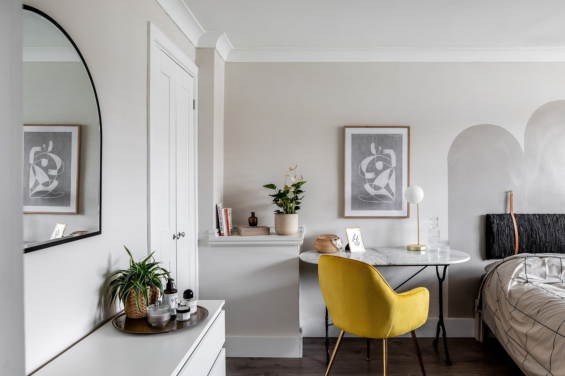 Neutral bedroom with mirror reflections and a yellow chair adding a pop of colour, showcasing interior design by Atelier Akuko in a London new build.