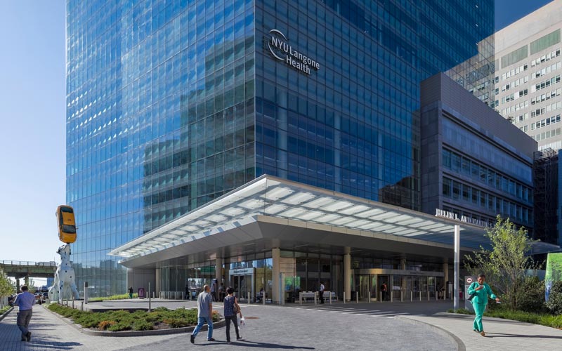 Black and white image of people working at a table with laptops, showing hands gesturing during discussion of digital content displayed on screens, with fabrica® logo in the corner.