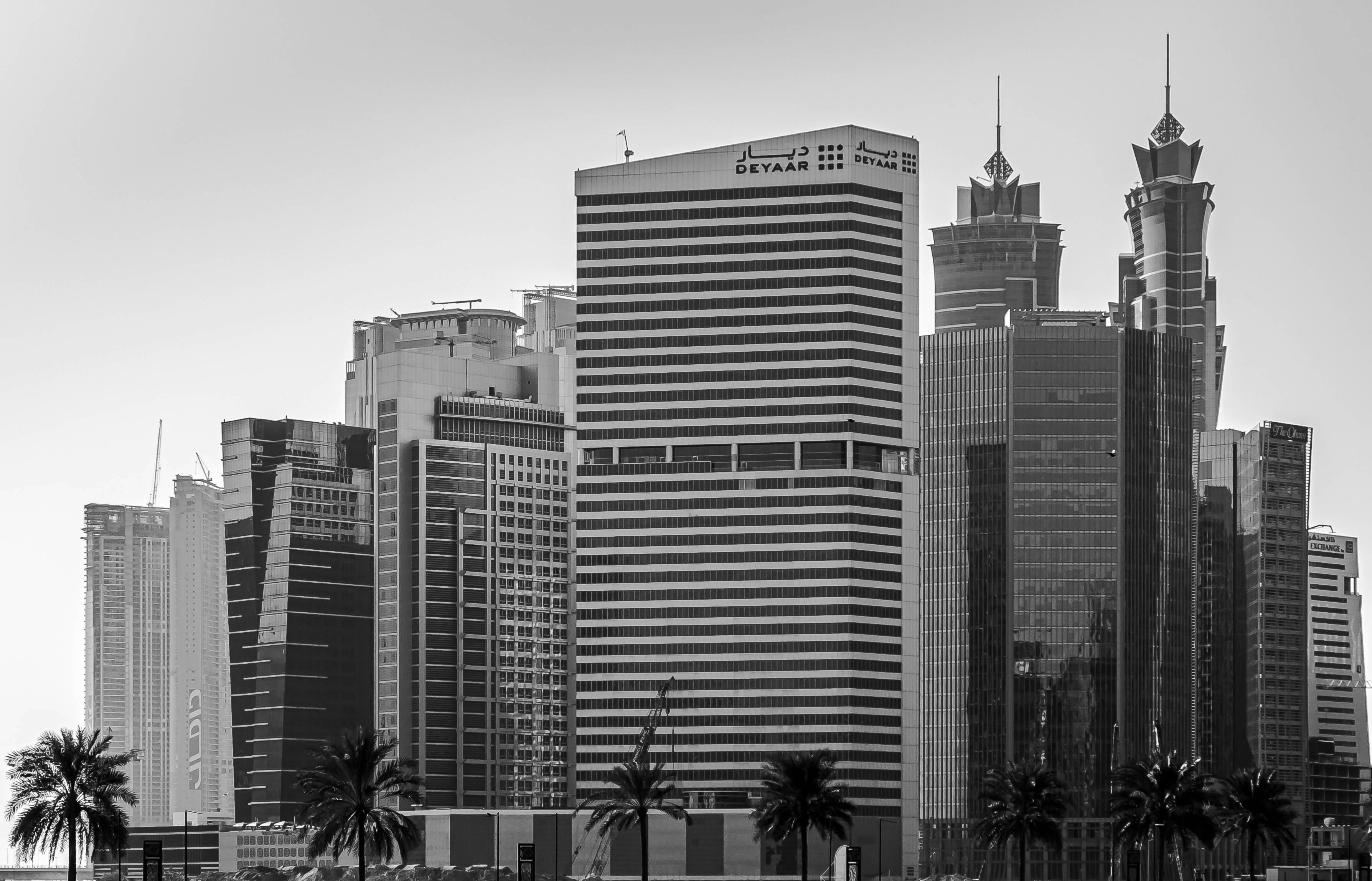 A black and white photo of Perth with tall tech and fintech buildings, and a grey sky without clouds in the background.