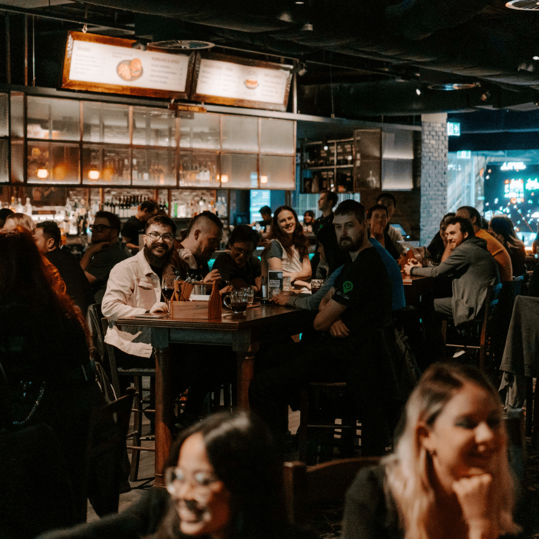 restaurant full of people playing trivia and laughing with drinks and food