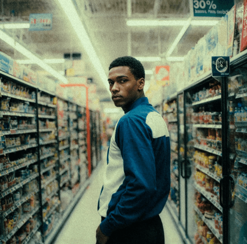 male standing in the middle of a grocery store aisle looking at camera