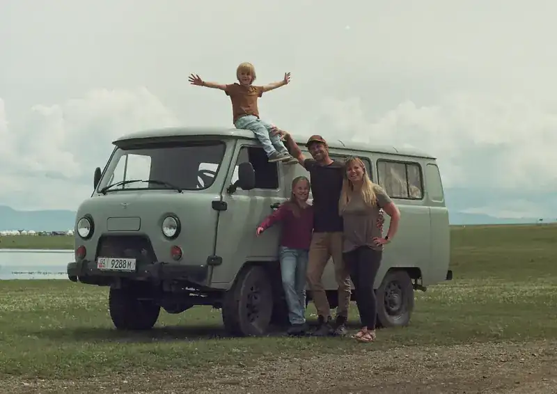 Georg, Tara, Liv and Bodhi with their van on a grassy plain in Kyrgyzstan