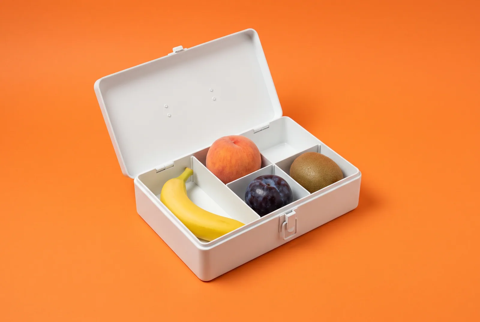 An open toolbox holding a banana, peach, plum and kiwi, what a good Remojo alternative needs to include