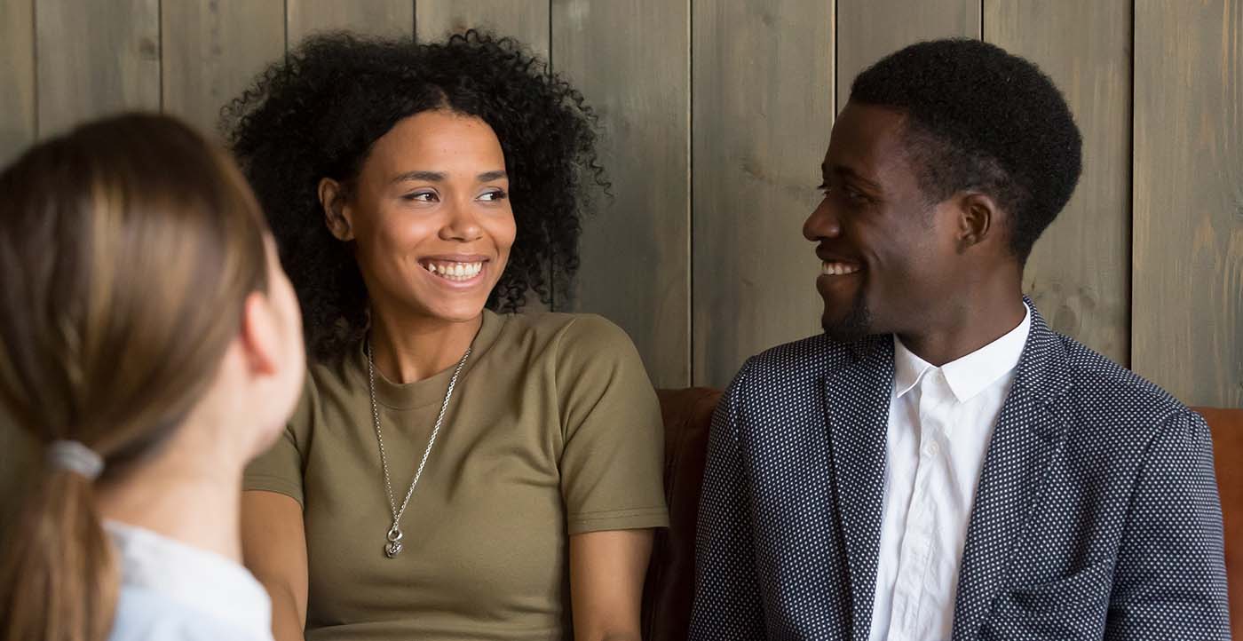 Couple smiling together while talking to doctor
