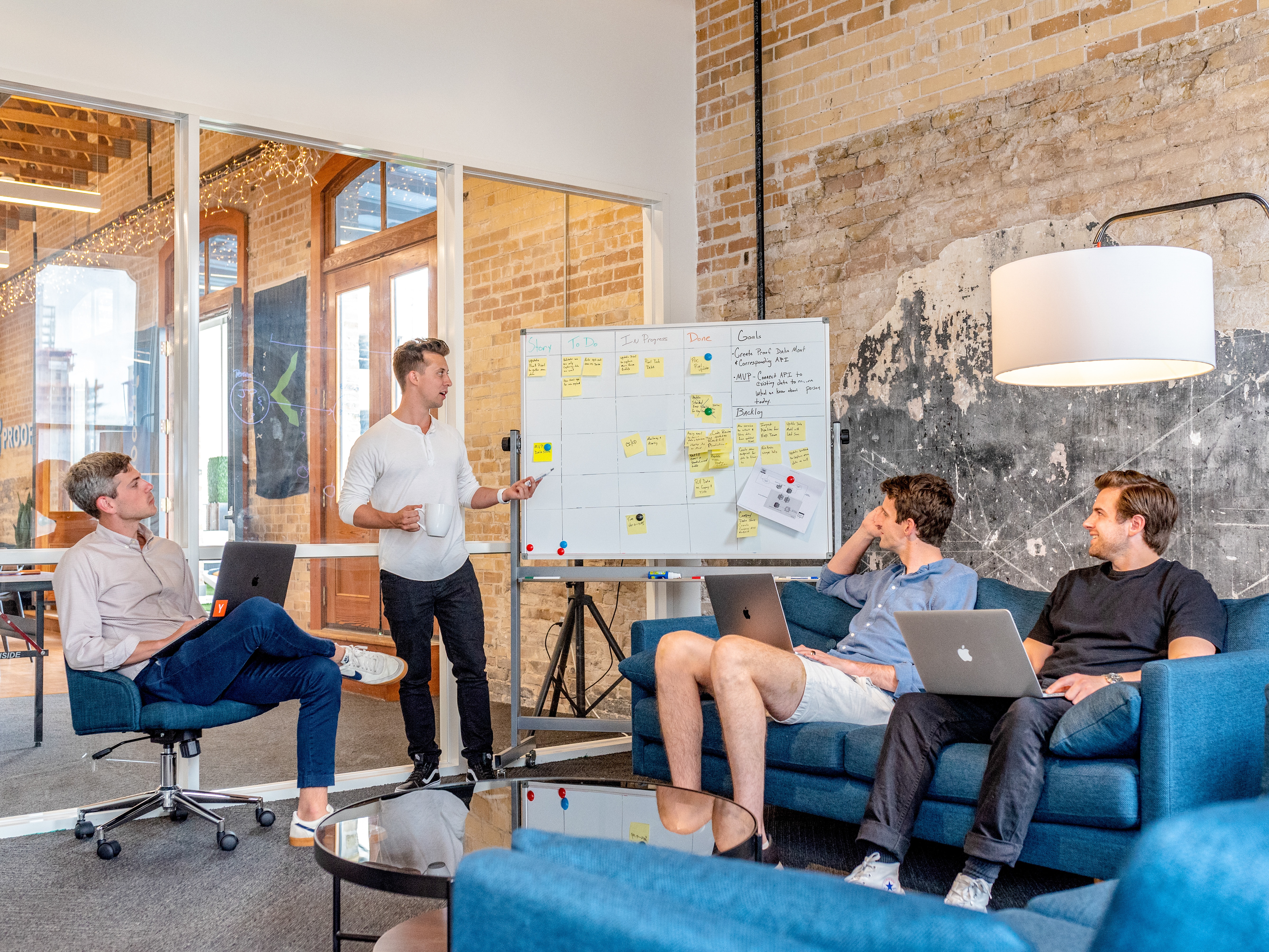 A startup team doing customer research using a whiteboard, collecting notes from interviews.