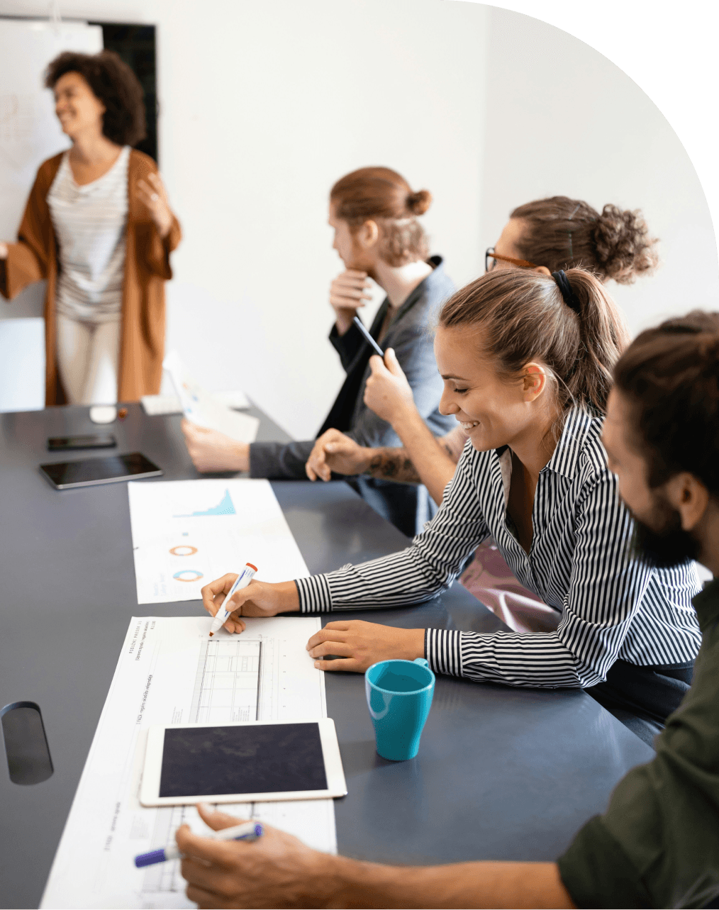 Team of young professionals in a meeting room, discussing documents and annual reports during 