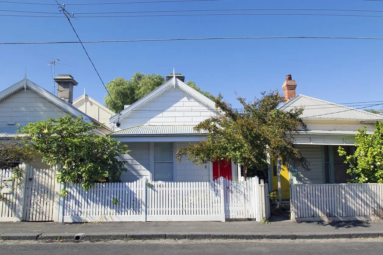 White houses with picket fences and trees