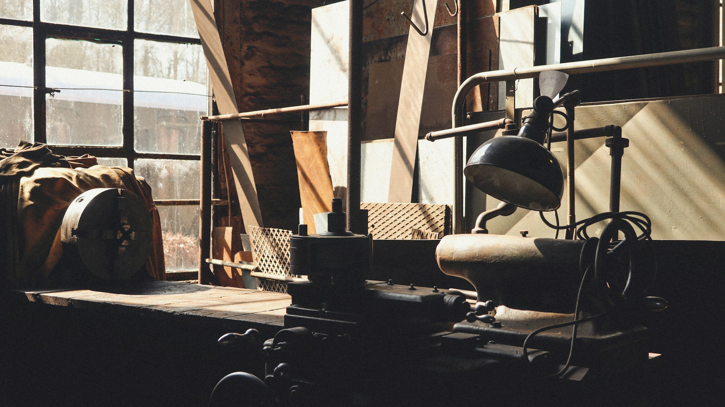 An old workshop bench with a lathe and window light