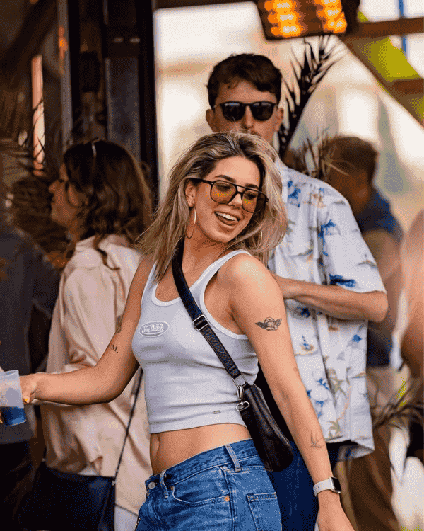 A woman and man in sunglasses dancing at a day event