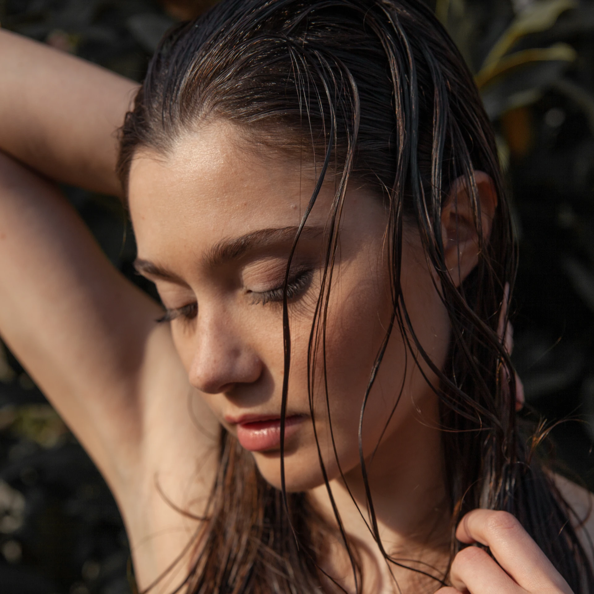 Woman running her hands through wet hair looking down