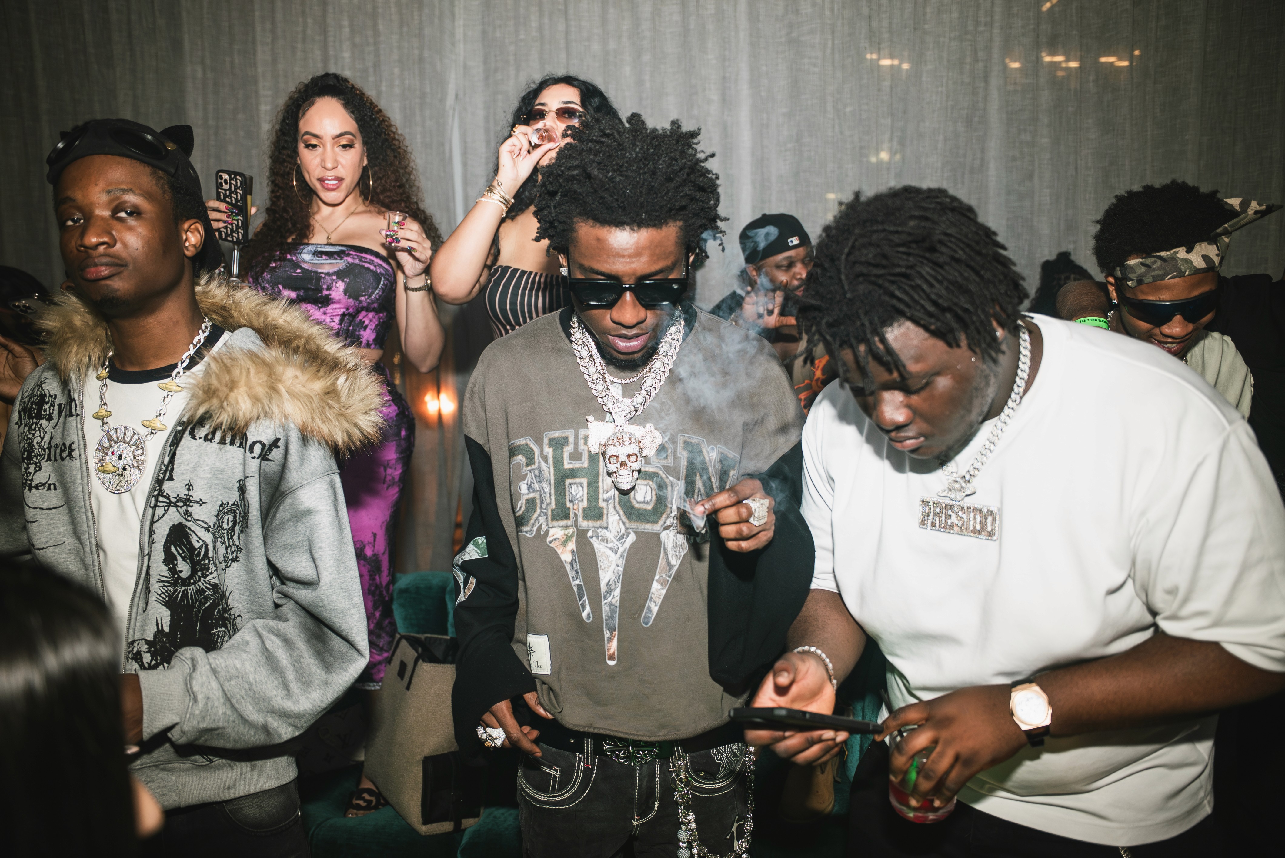 woman in red tank top and blue denim shorts standing beside woman in black tank top