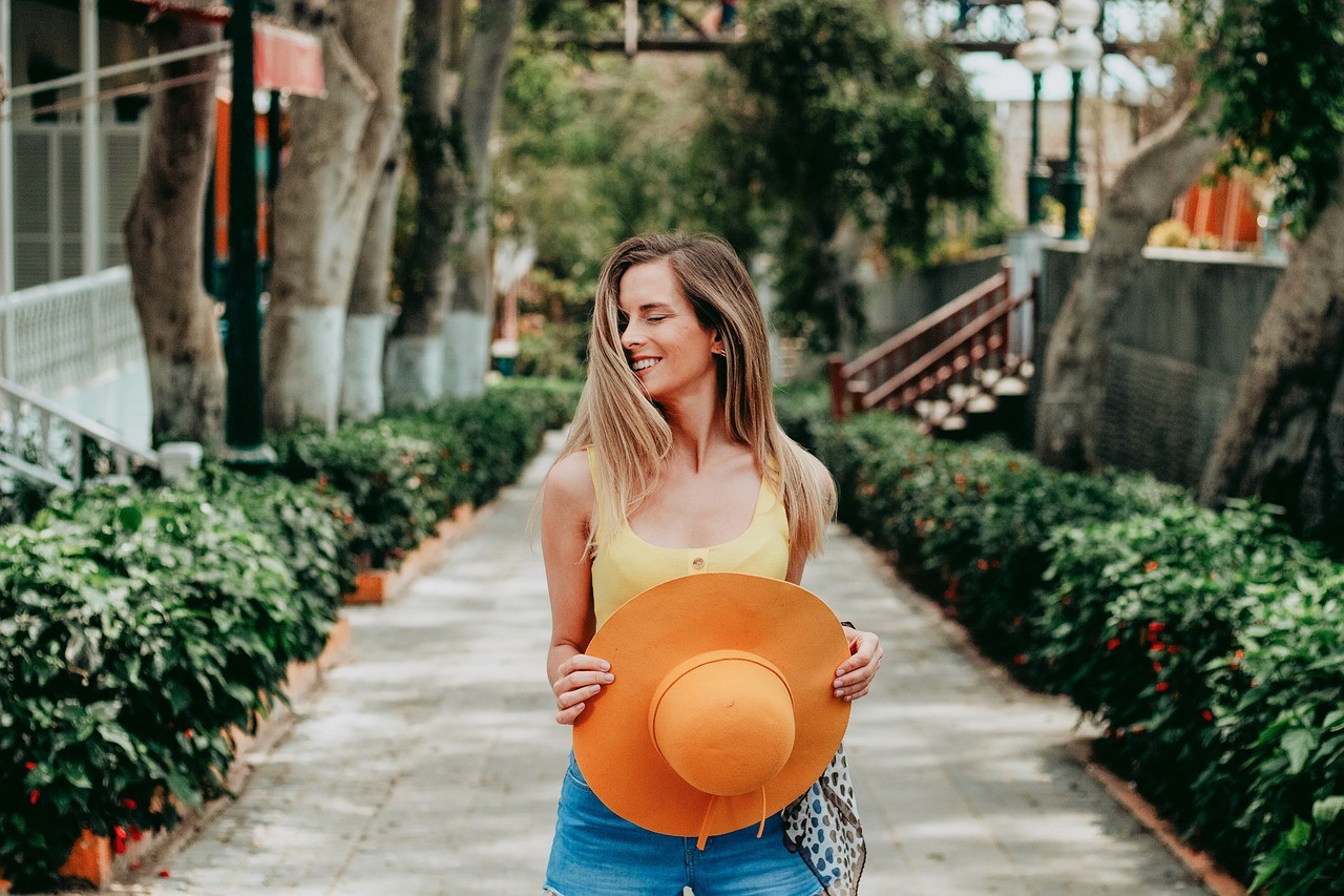 Happy woman holding orange hat