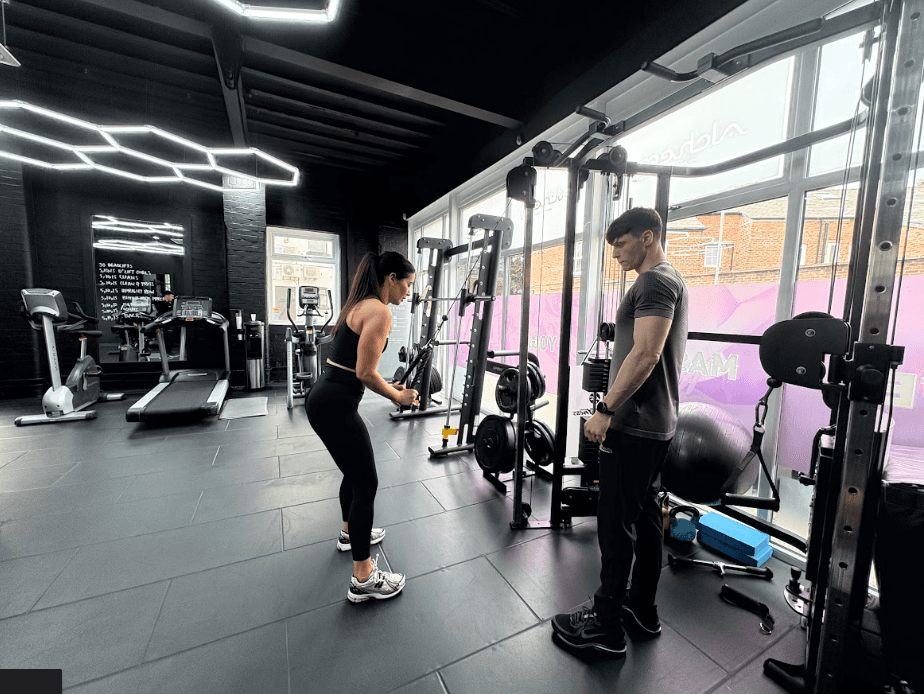 Personal trianer in Wilmslow coaching a client while doing resistance training in preparation for her marathon.