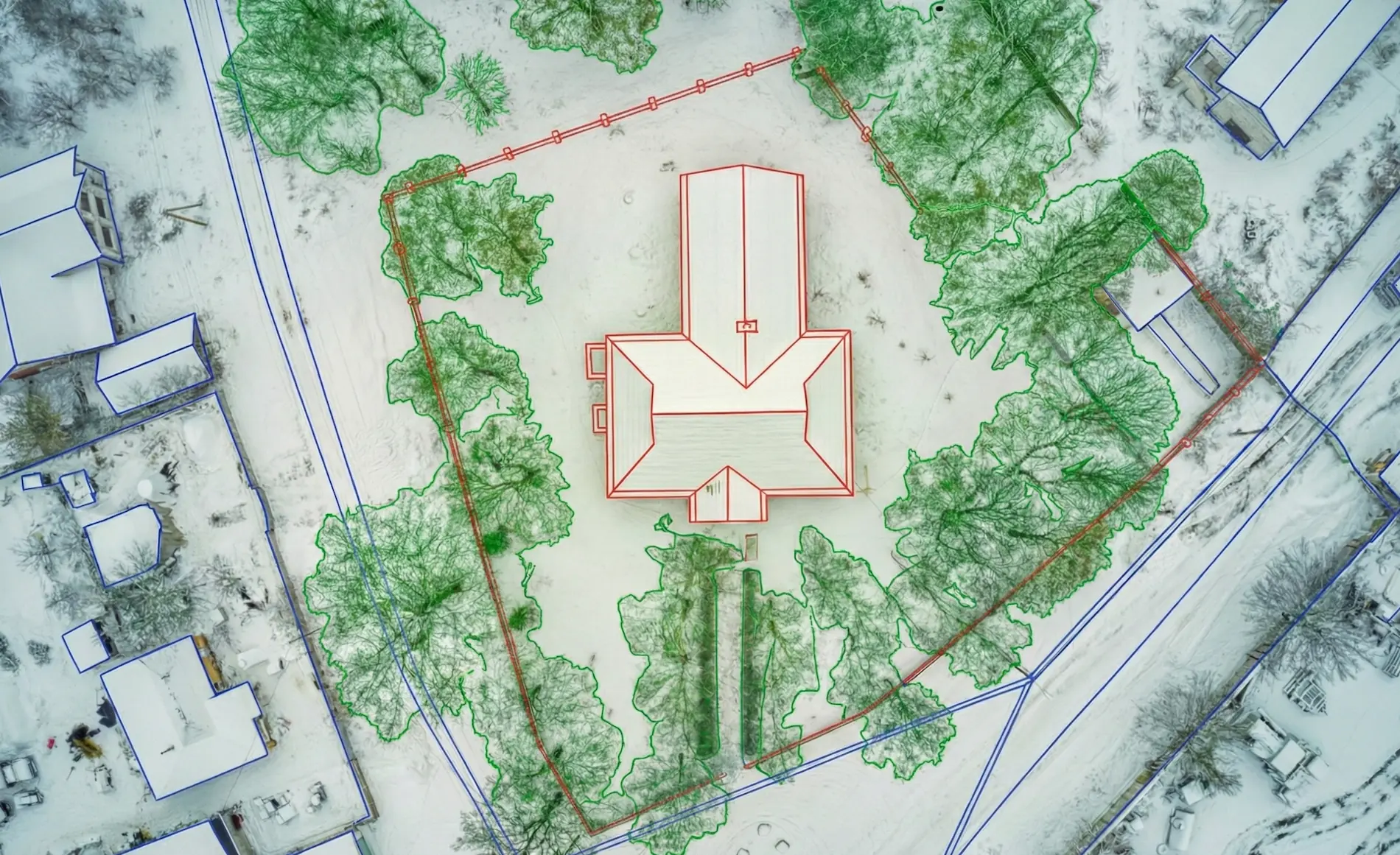 Aerial site survey showing digital mapping with red building outlines and green tree boundaries