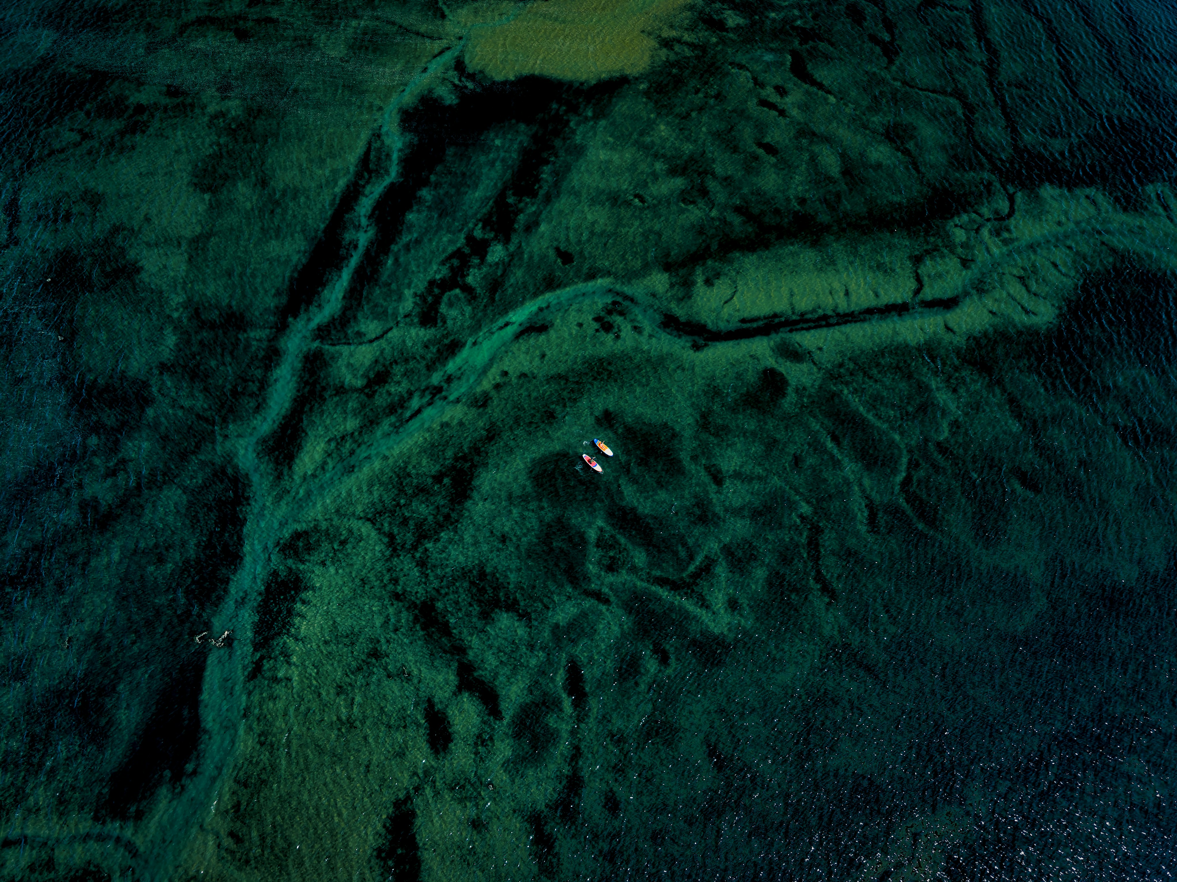 Aerial view of vibrant green and blue waters.