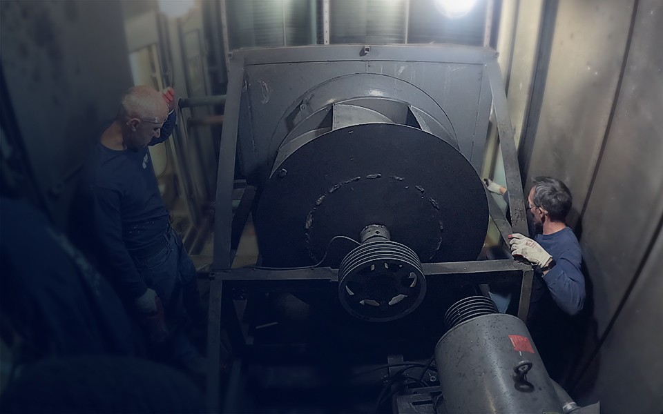 GRR Cooling Experts technicians performing commercial HVAC maintenance and repair on large air handling equipment inside a mechanical room.