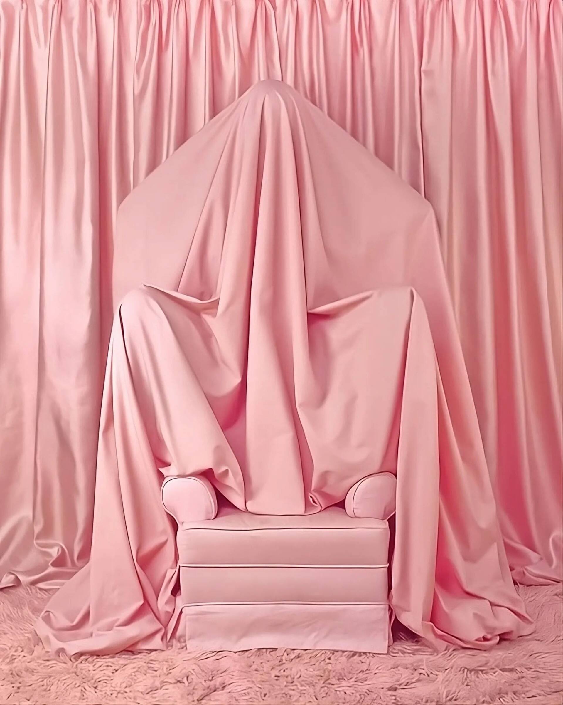A pink room with a pink chair draped in pink fabric, surrounded by pink curtains and a pink fluffy rug.