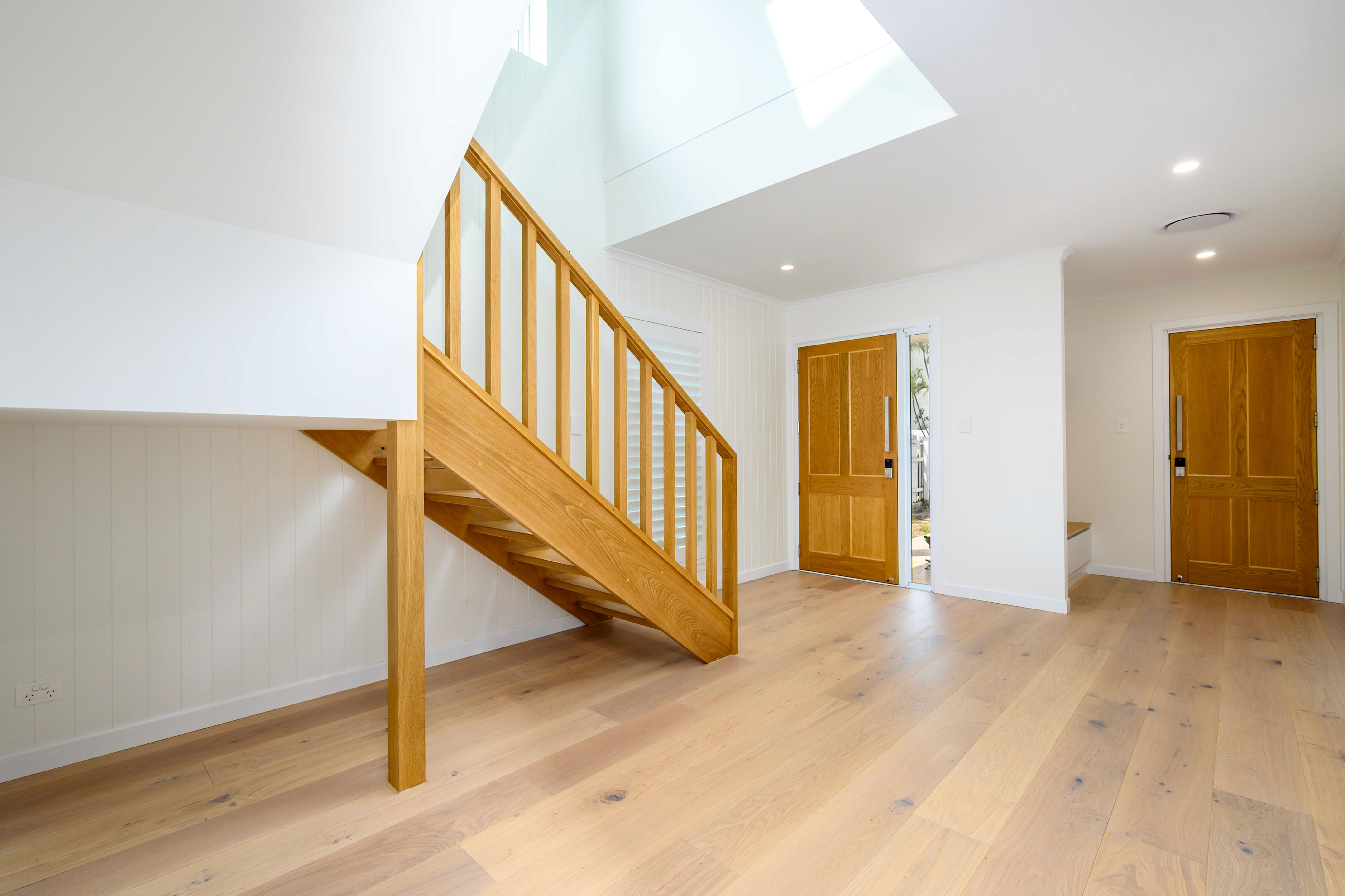 Freshly painted white hallway with timber staircase — Gold Coast interior painting by Red Dragon Painting