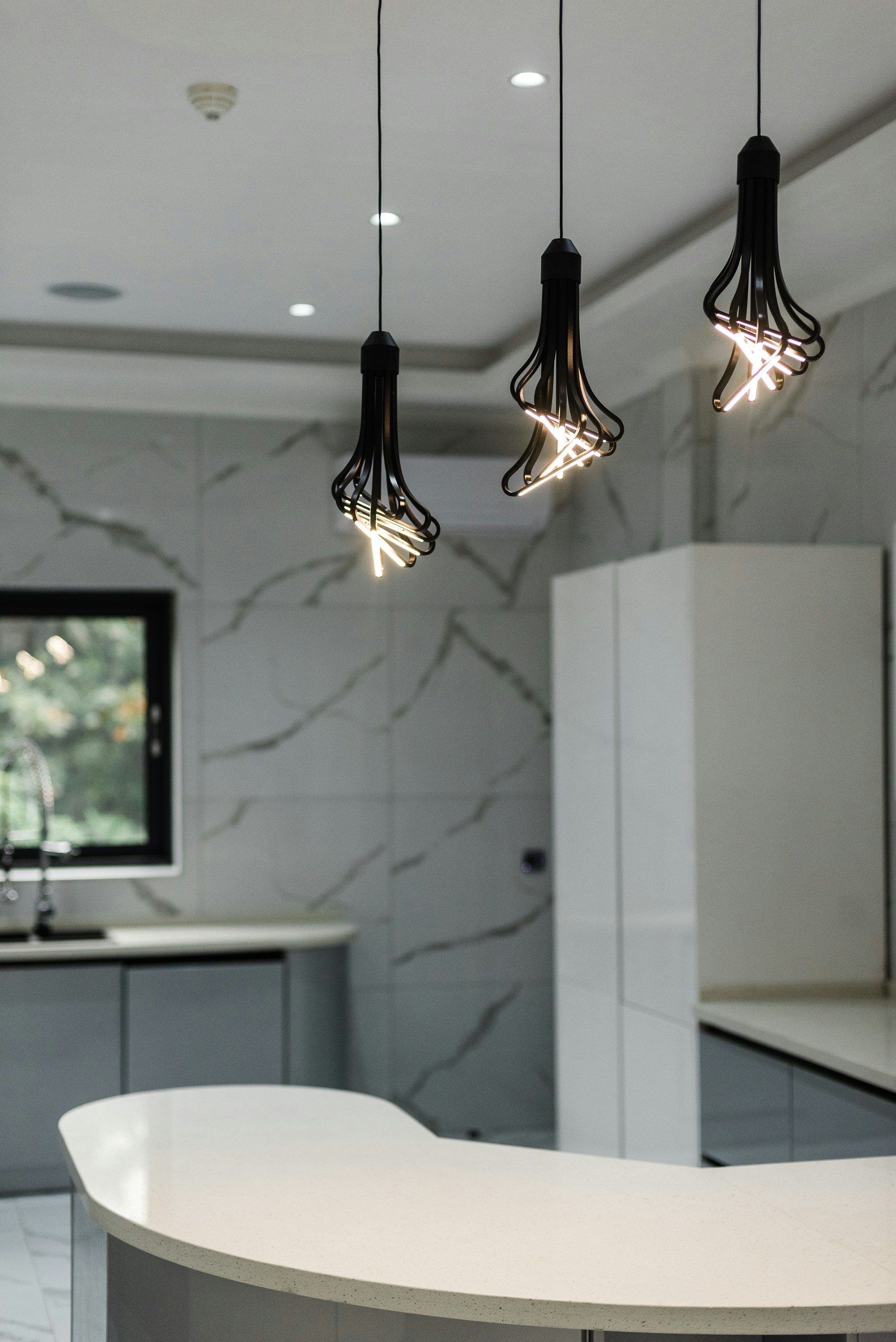 Modern bathroom with marble walls and a freestanding bathtub.