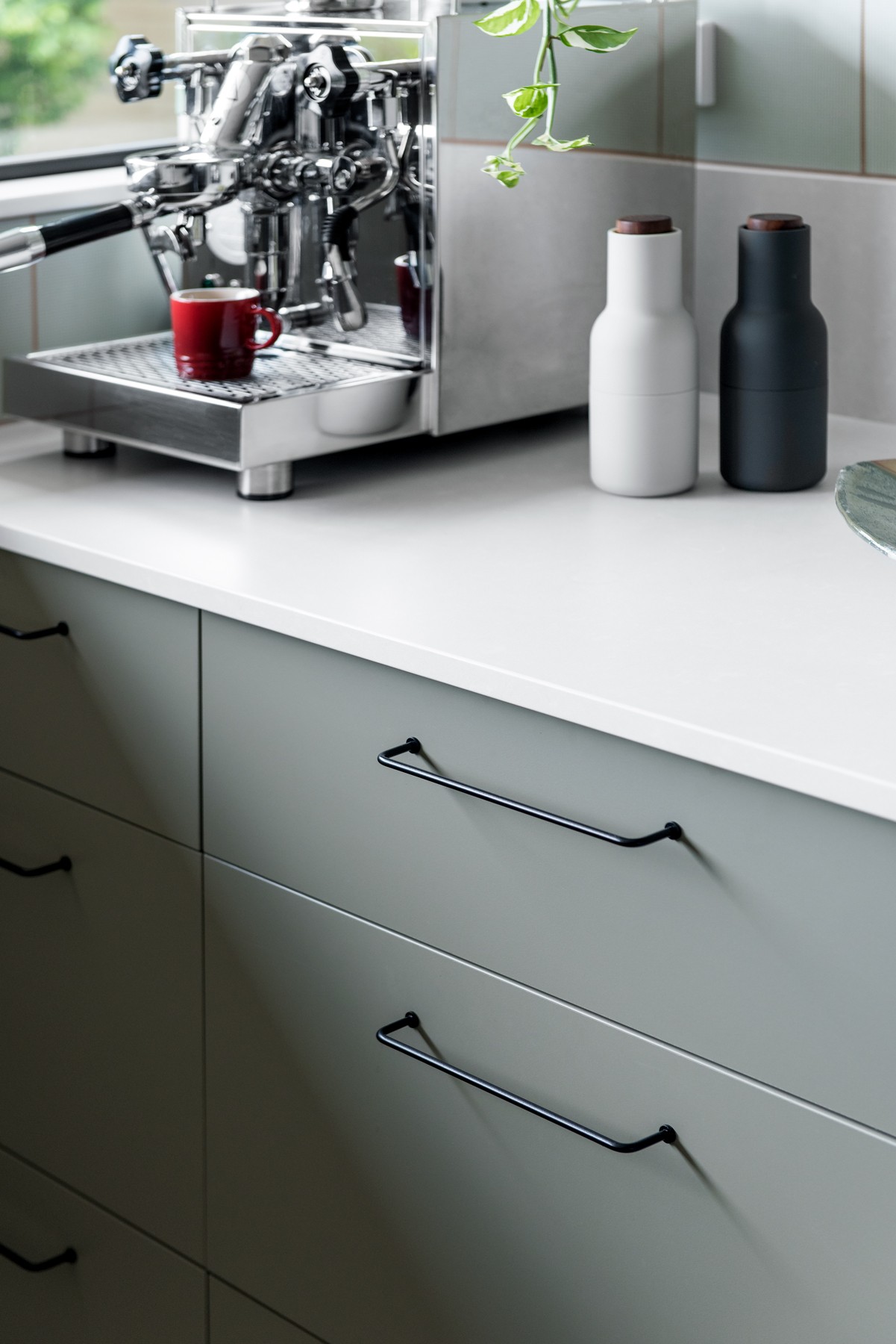 Joinery detail at Glenhaven Kitchen, highlighting soft green cabinetry, integrated handles, and a clean white benchtop with coffee station.