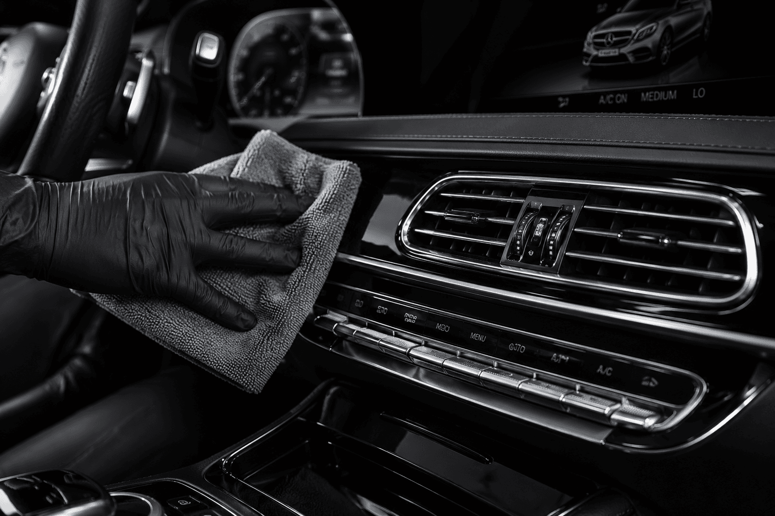 Detailer carefully cleaning a vehicle dashboard