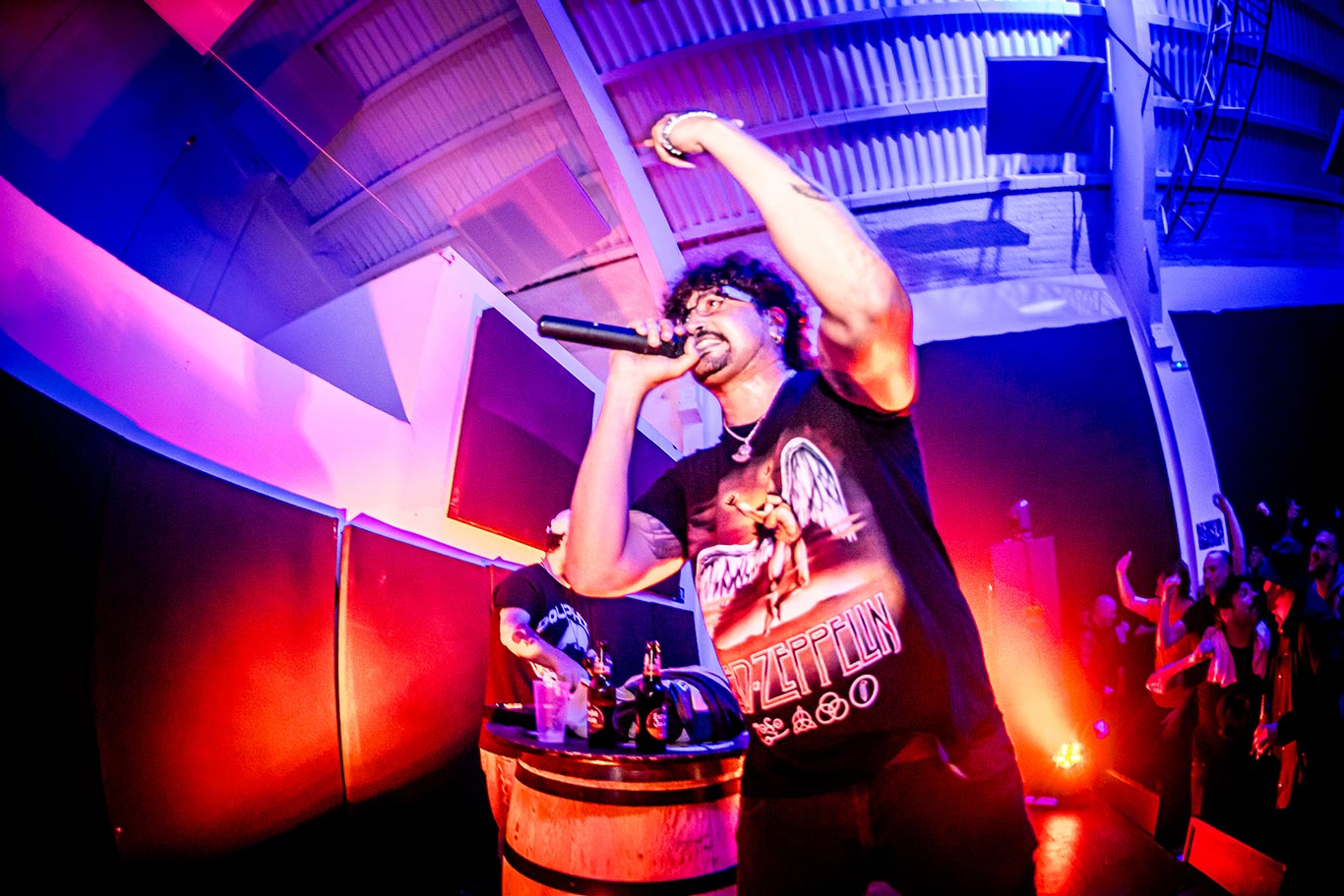 Young leady in green sweater asks a question into a conference mic.