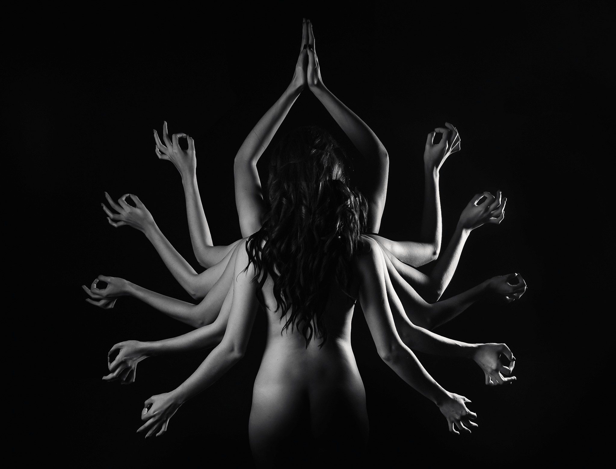 A grey car parked in a grass field in a hilly area