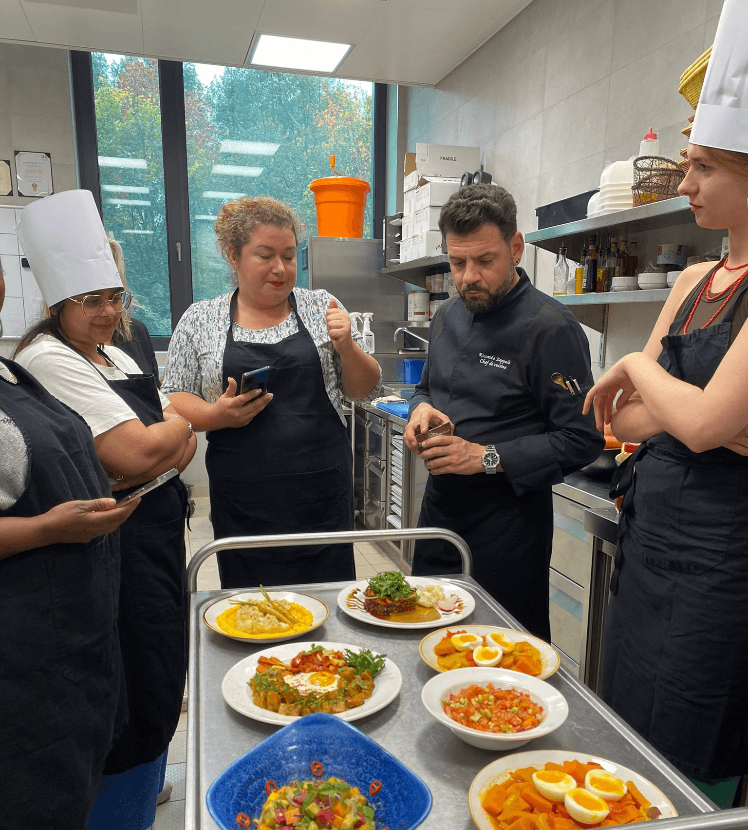 Chefs & trainees looking at dishes placed on a trolley
