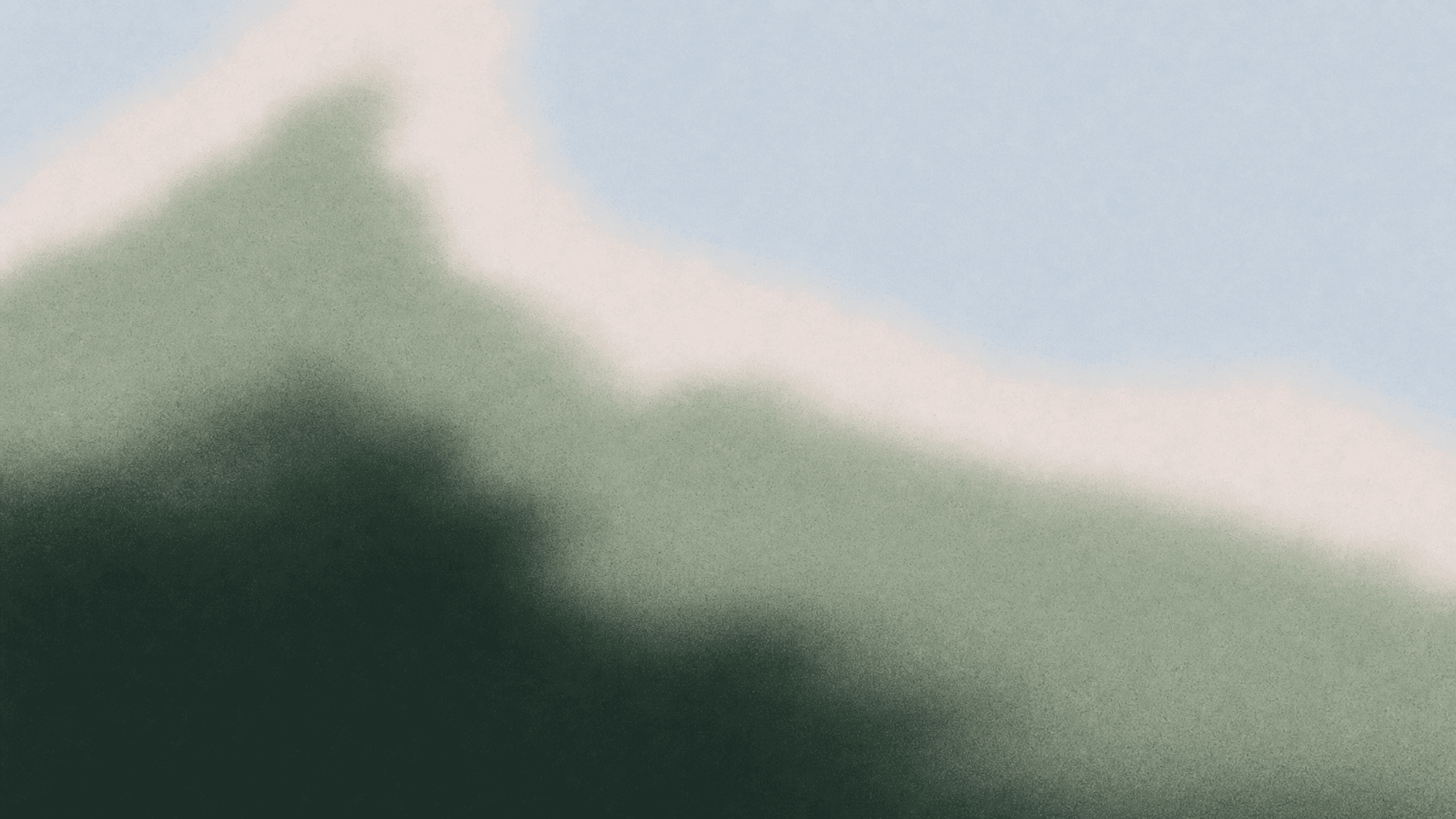 Soft green mountain ridge fading into a pale sky