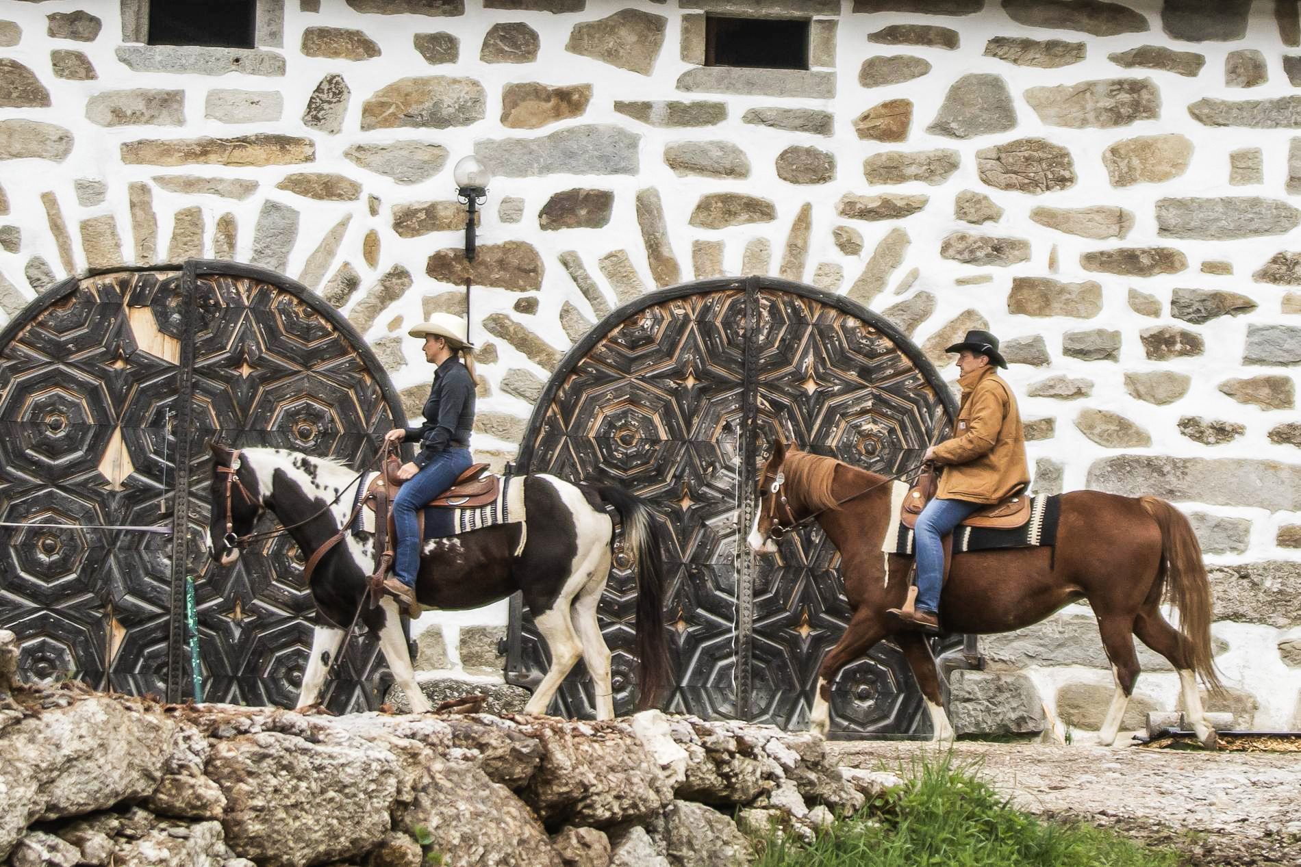 Zwei Reiter auf einer Wanderreit-Tour durch das Mühlviertler Kernland vor historischer Steinarchitektur